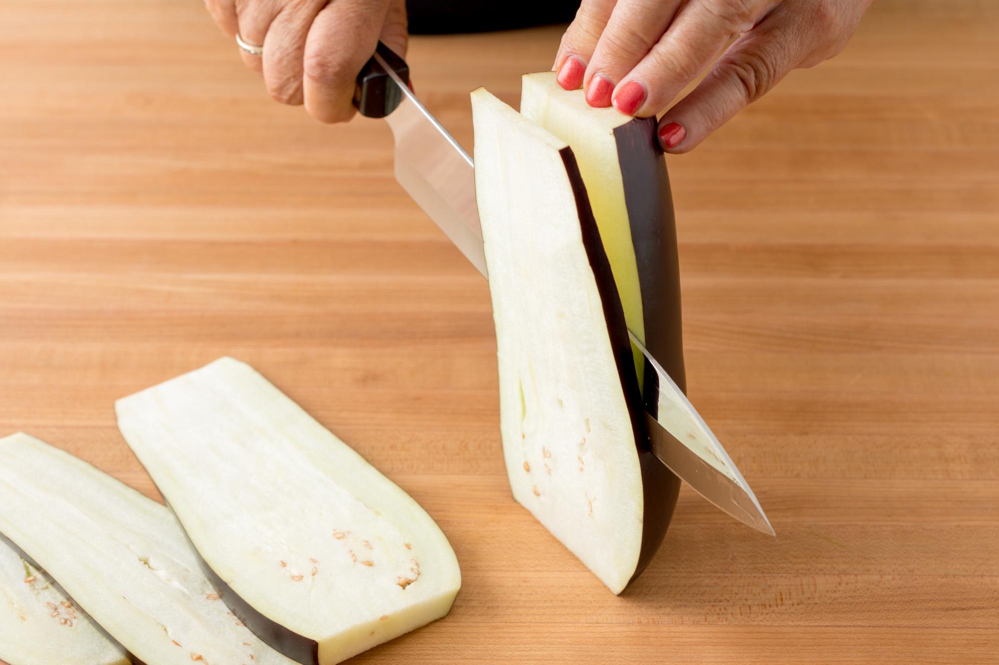 Cutting eggplant slices into bread … – License image – 10173092