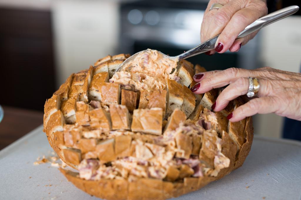 Spooning the mixture into the bread.