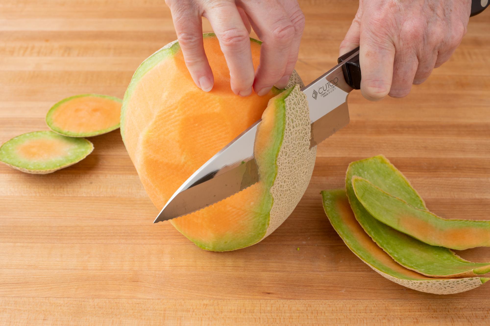 Using the Gourmet Prep Knife to remove the rind of the cantaloupe.