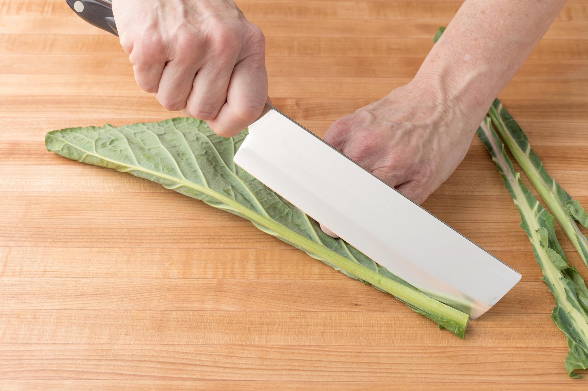 Slicing the stem of the collard greens with a Vegetable Knife.