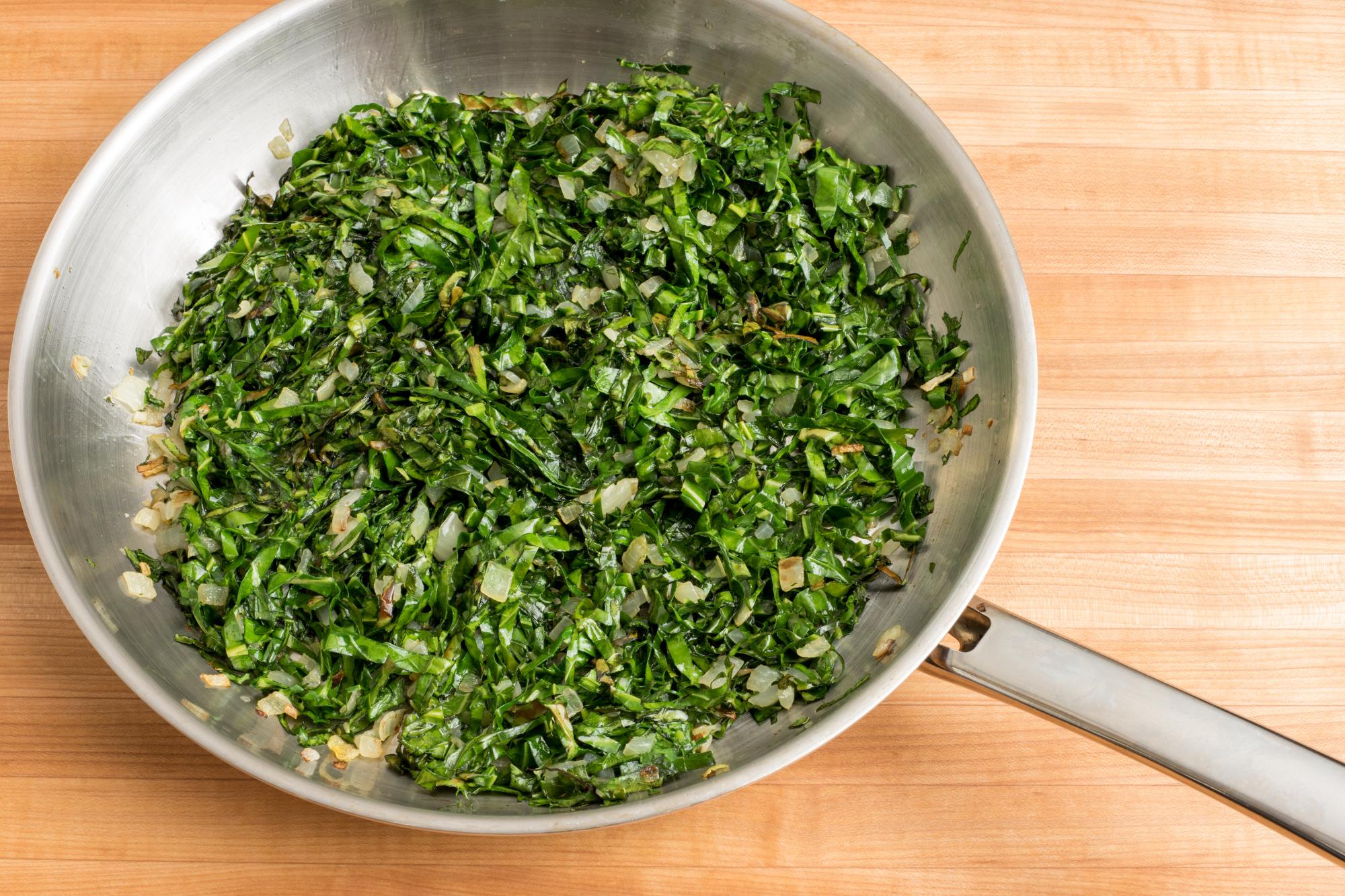 Collard greens cooking in pan.