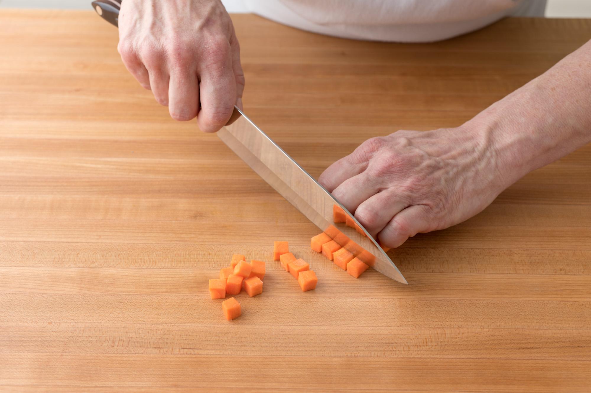 A Petite Chef being used to dice carrots.