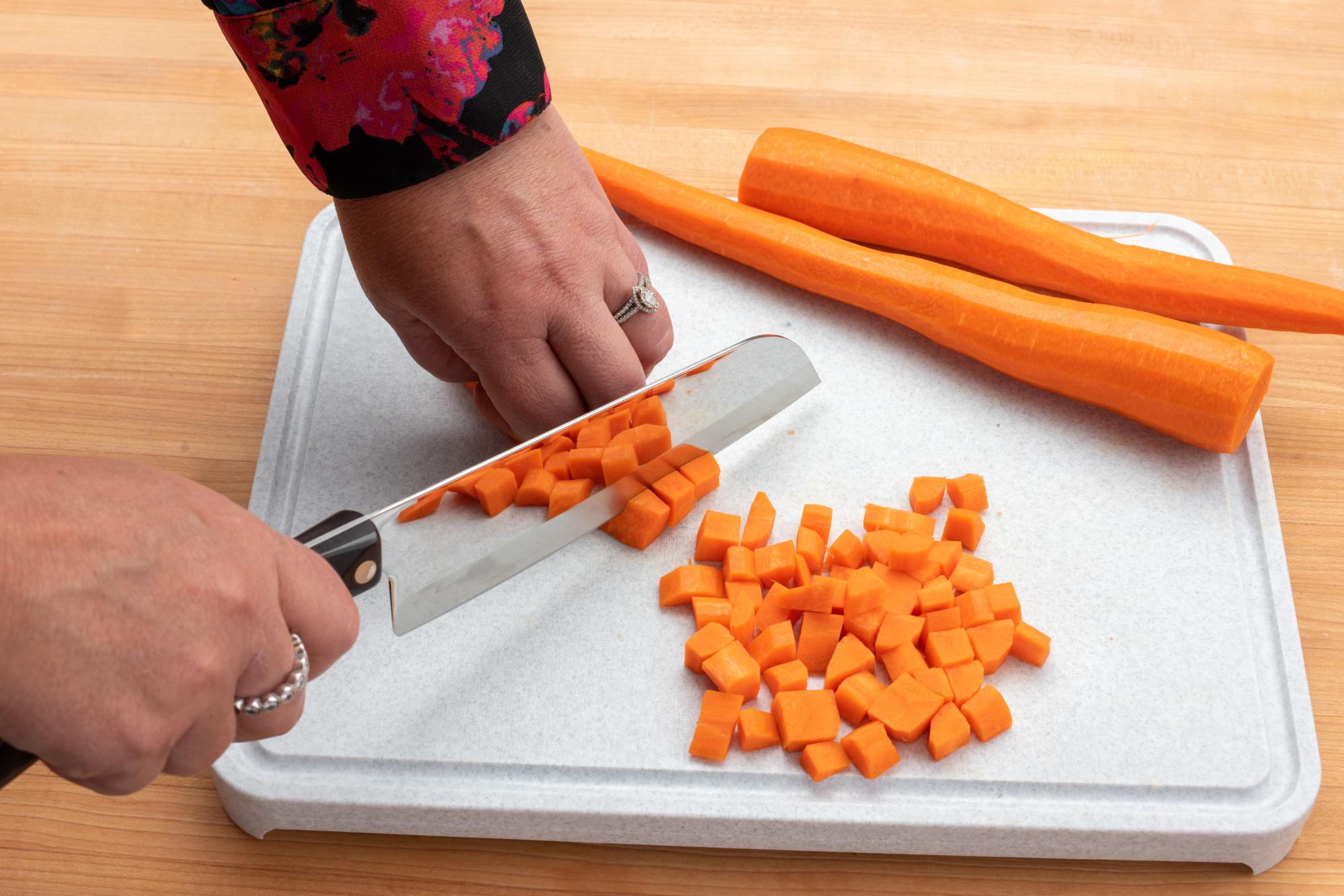 Chopping carrots with a Santoku.