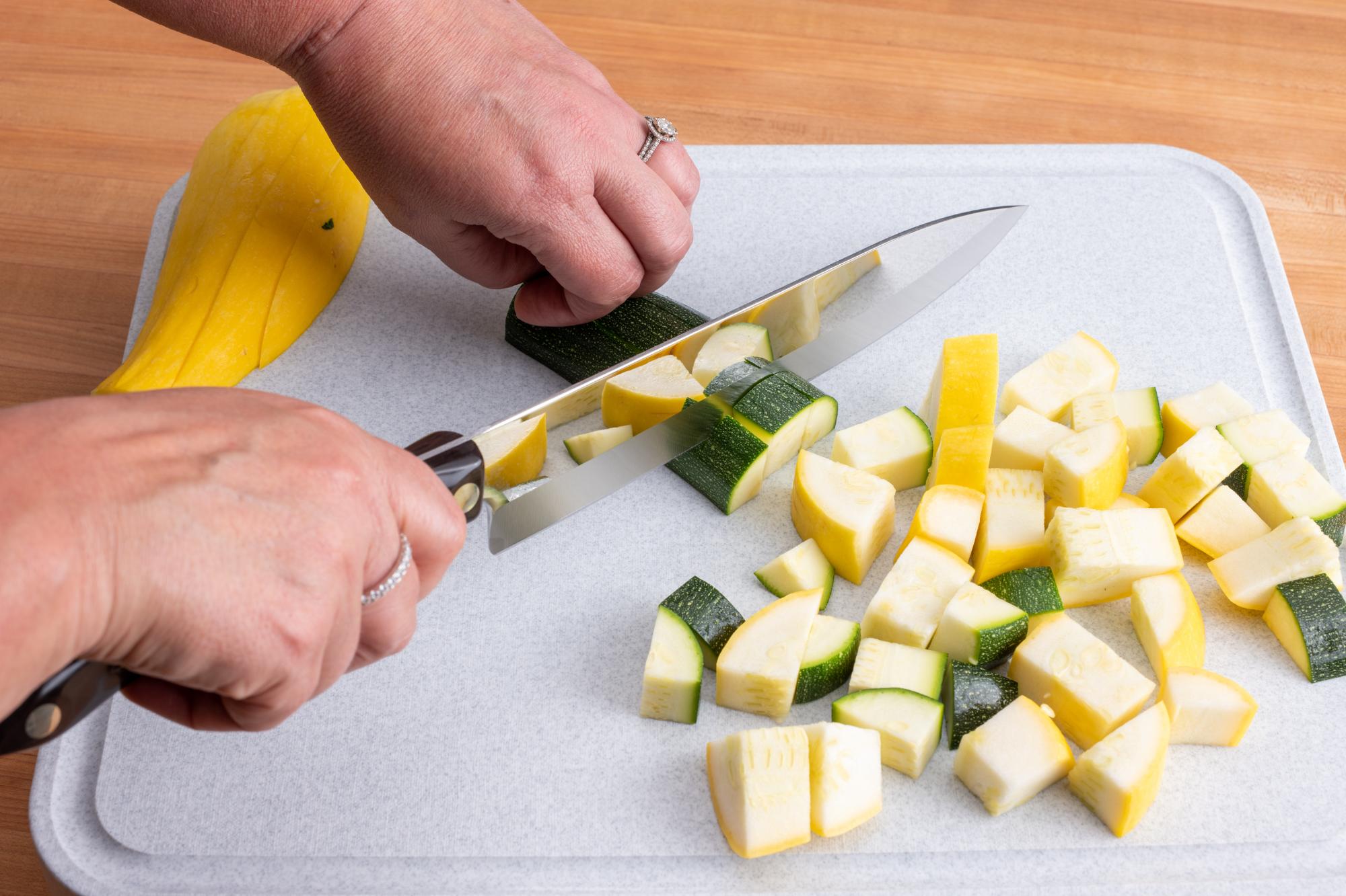 French Chef knife dicing zucchini and yellow squash.