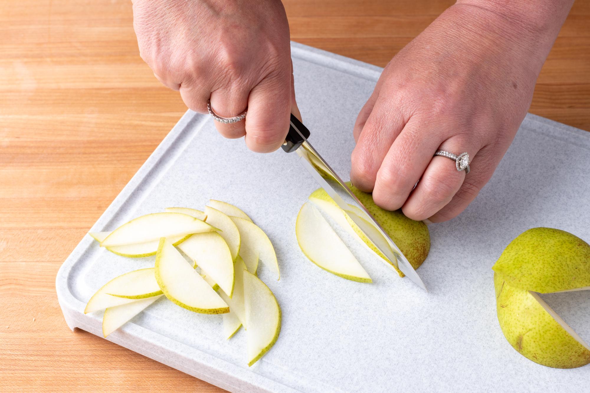 Using the 4 inch Paring knife to slice the pear.