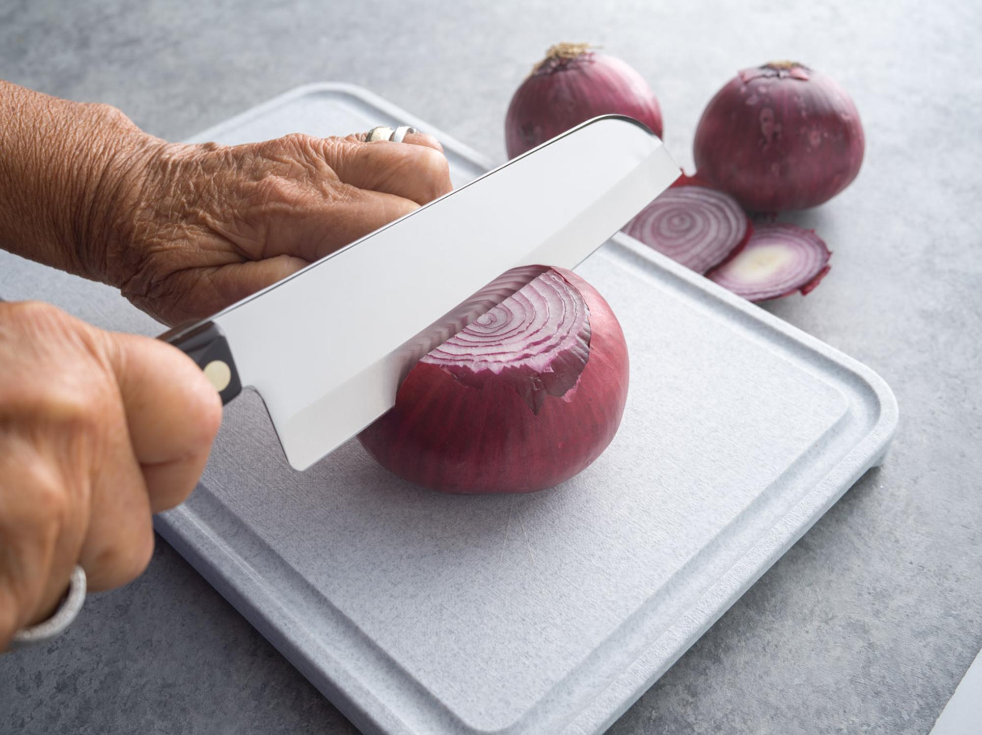 Cutting red onion with a Santoku.