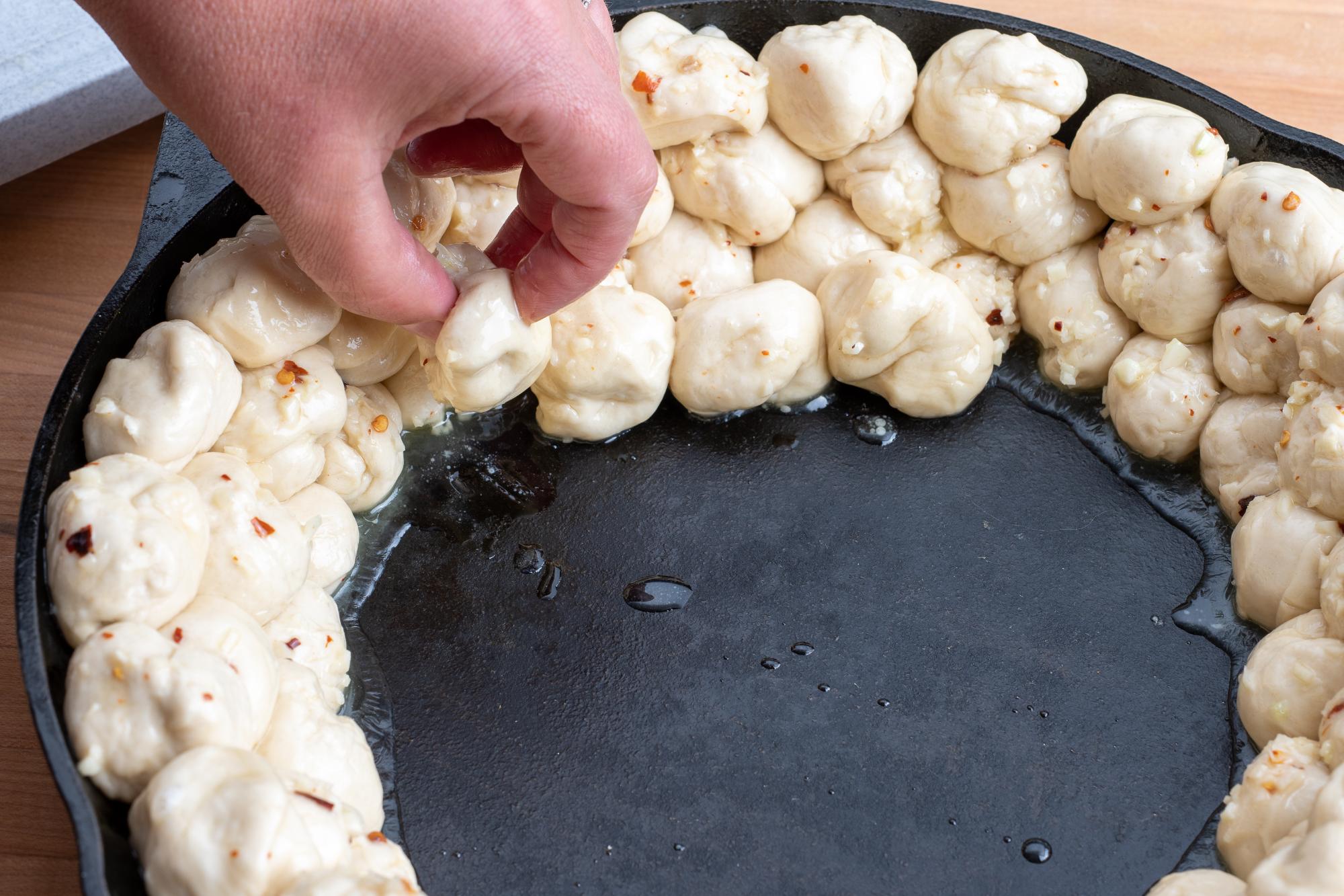 Placing the dough balls in the skillet.