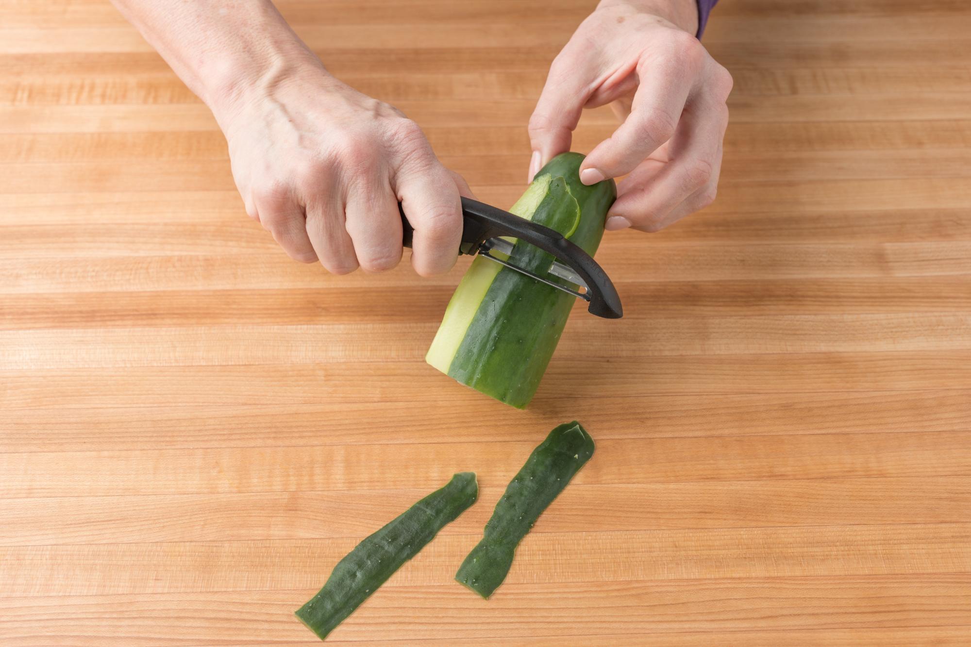 Peeling cucumber with a Vegetable Peeler.