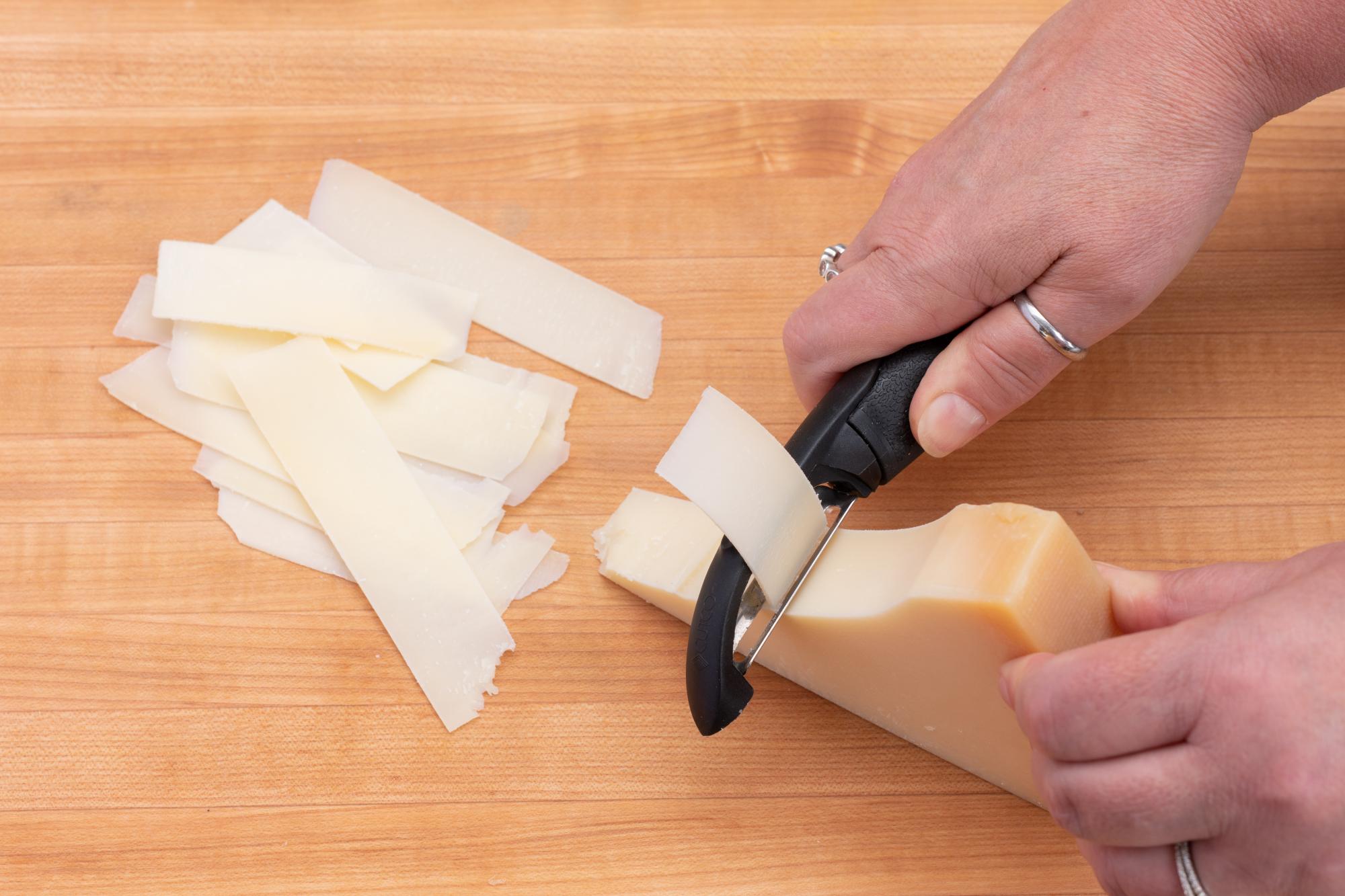 Shaving the parmesan cheese with a Vegetable Peeler.