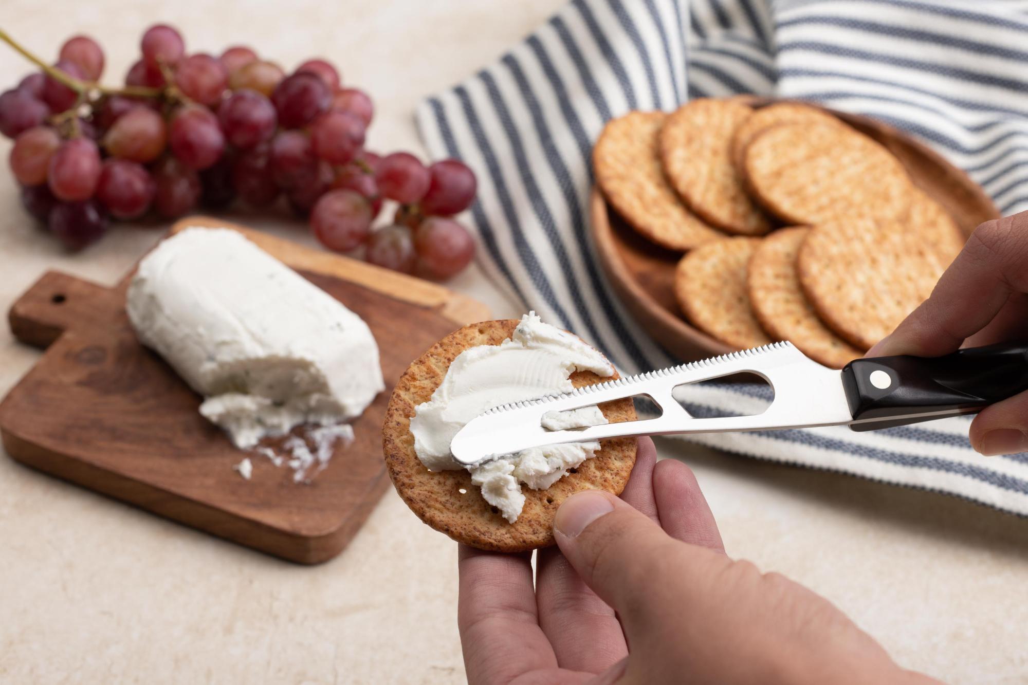 Premium Photo  The chef cuts the goat cheese with a special cheese knife  the concept of the production and sale of