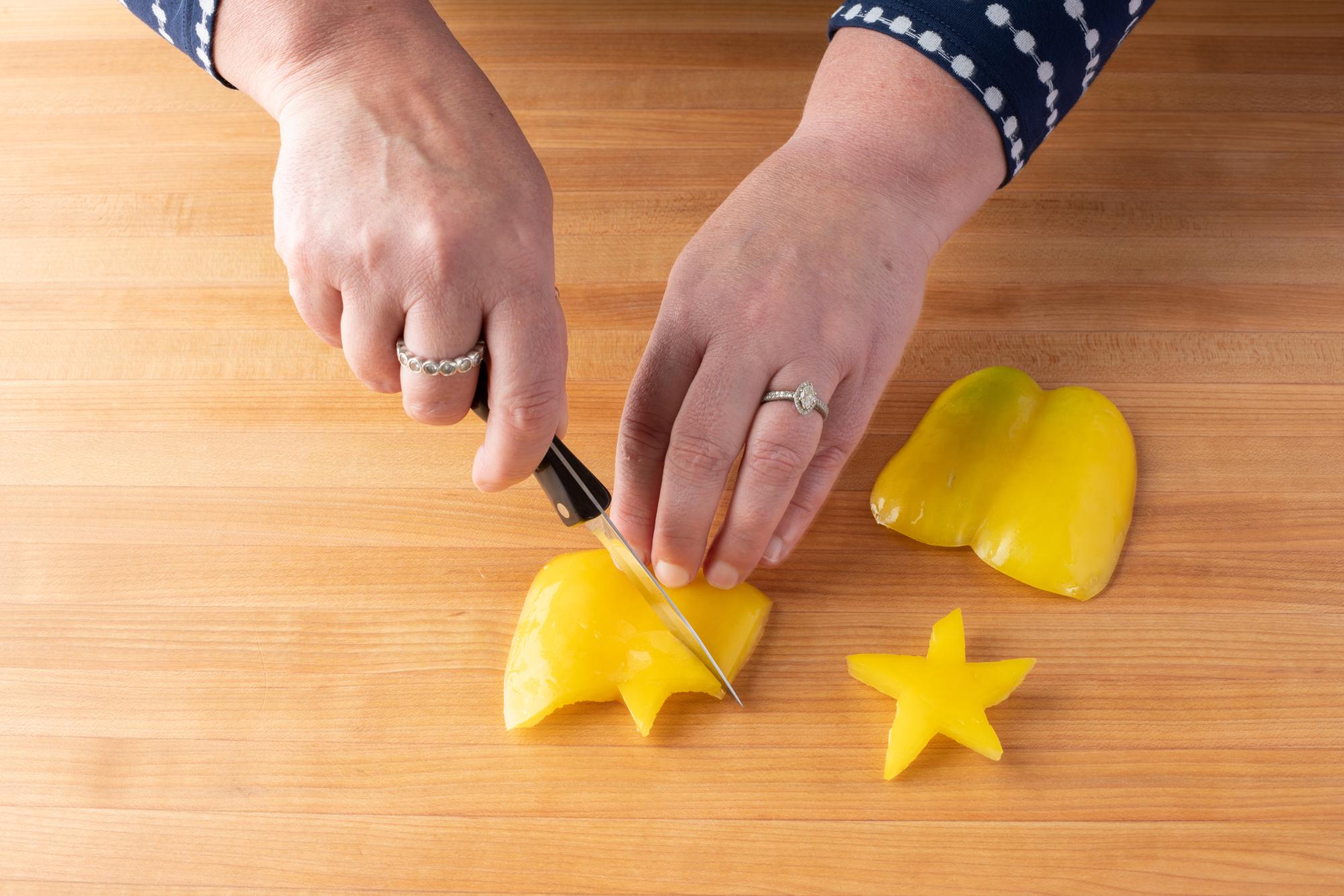 Cutting a star out of the yellow bell pepper with a Paring Knife.