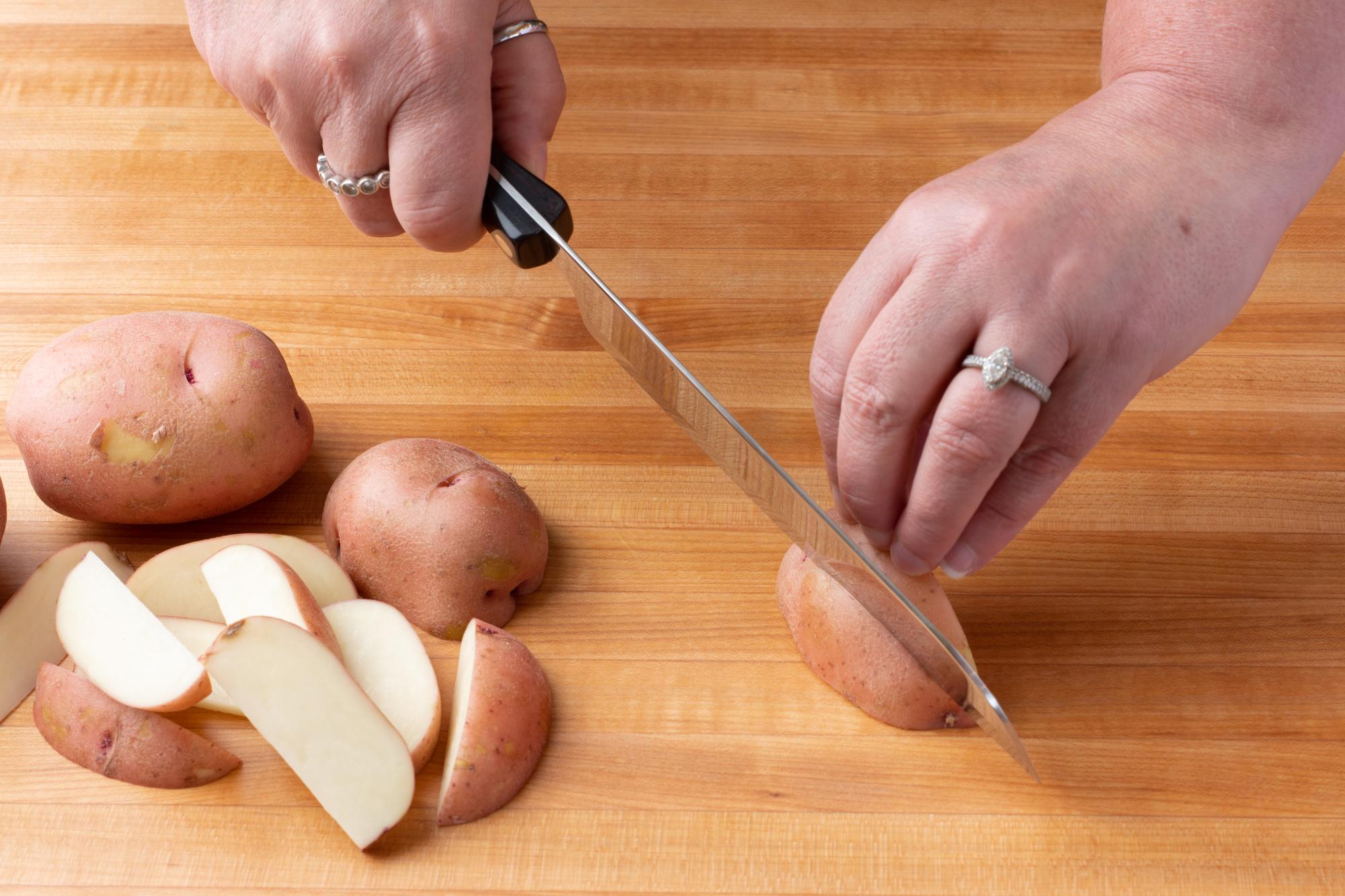 Cutting the potatoes with a Santoku.