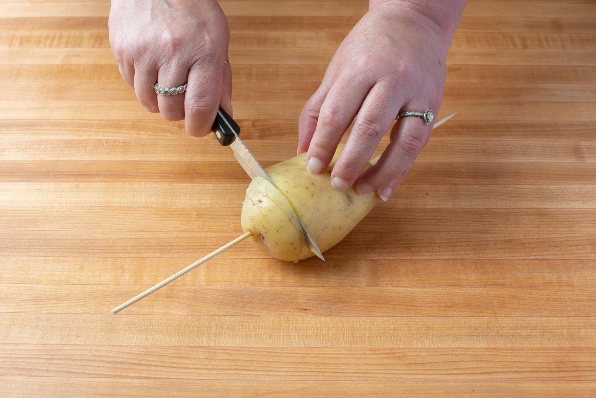 Using the 4 Inch Paring knife to cut the potato.