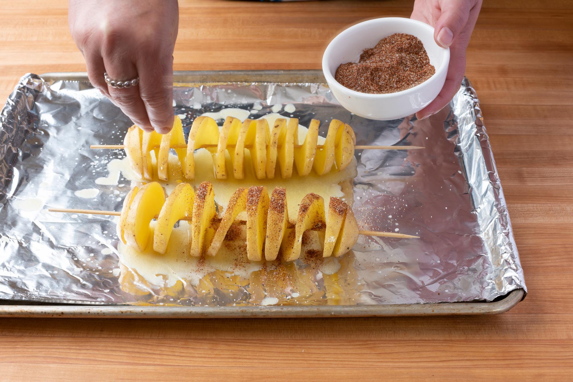 Sprinkling the potato with the spice mixture.