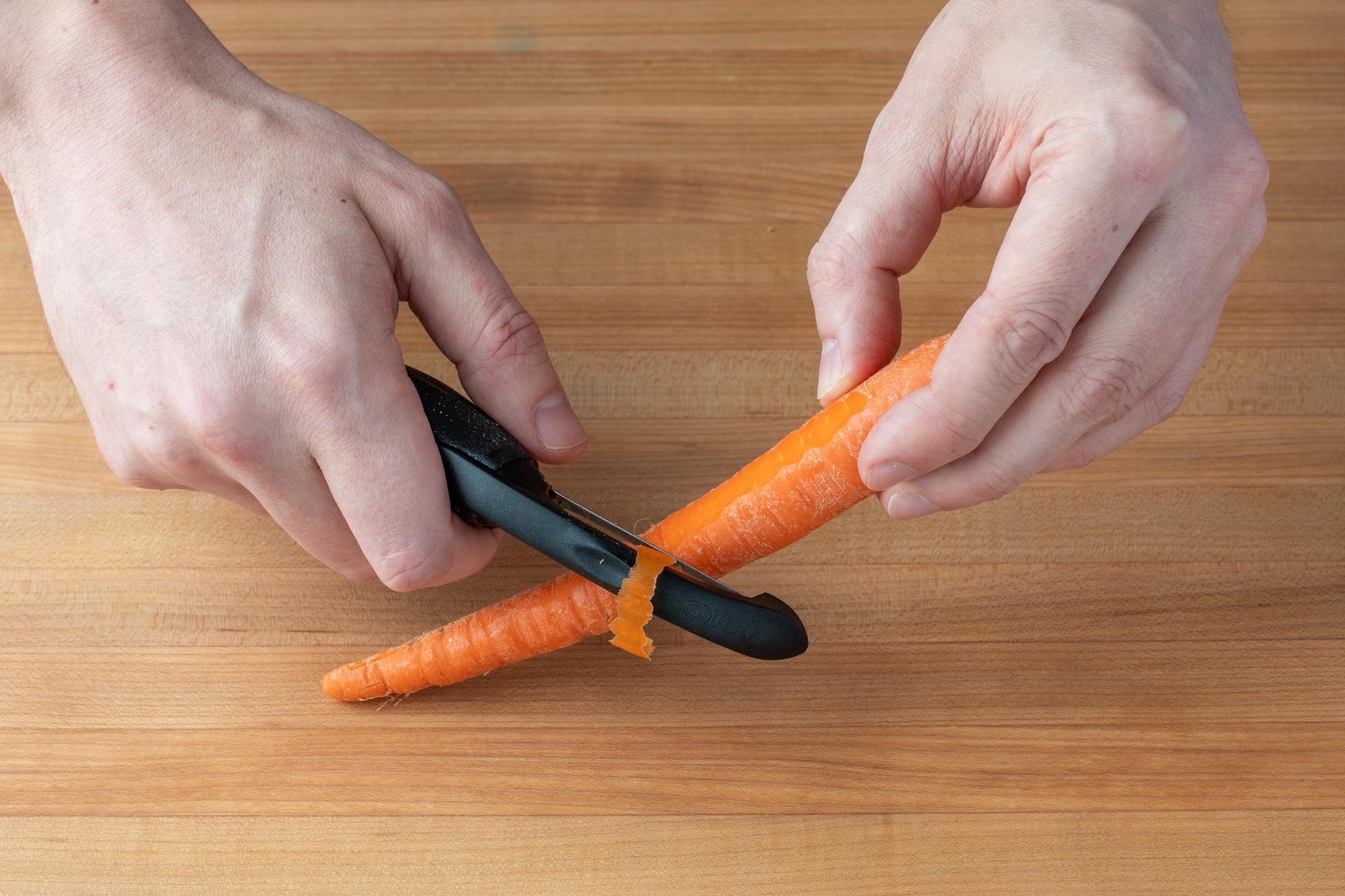 Peeling the carrot with a Vegetable Peeler.