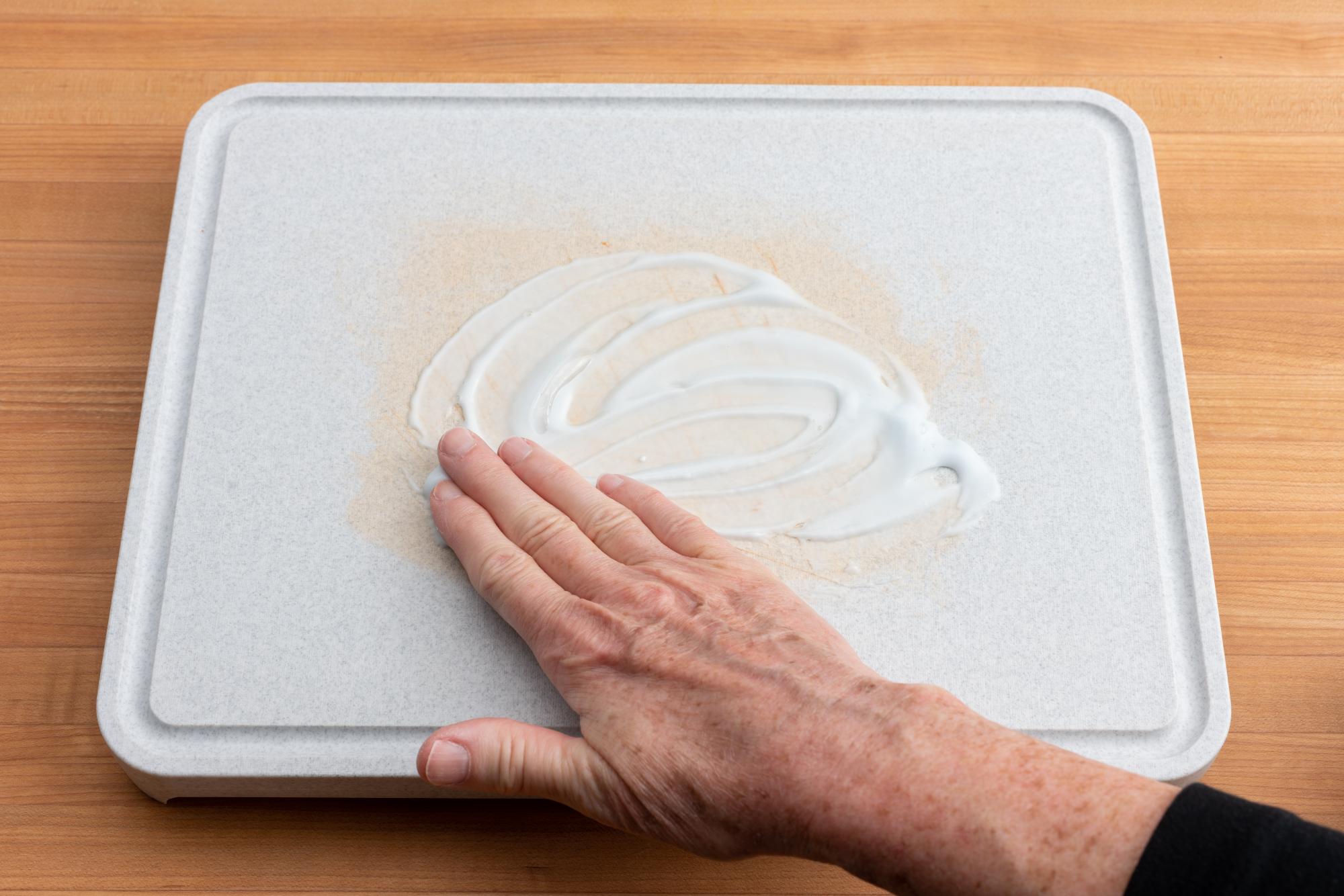 Rubbing the paste onto the board.