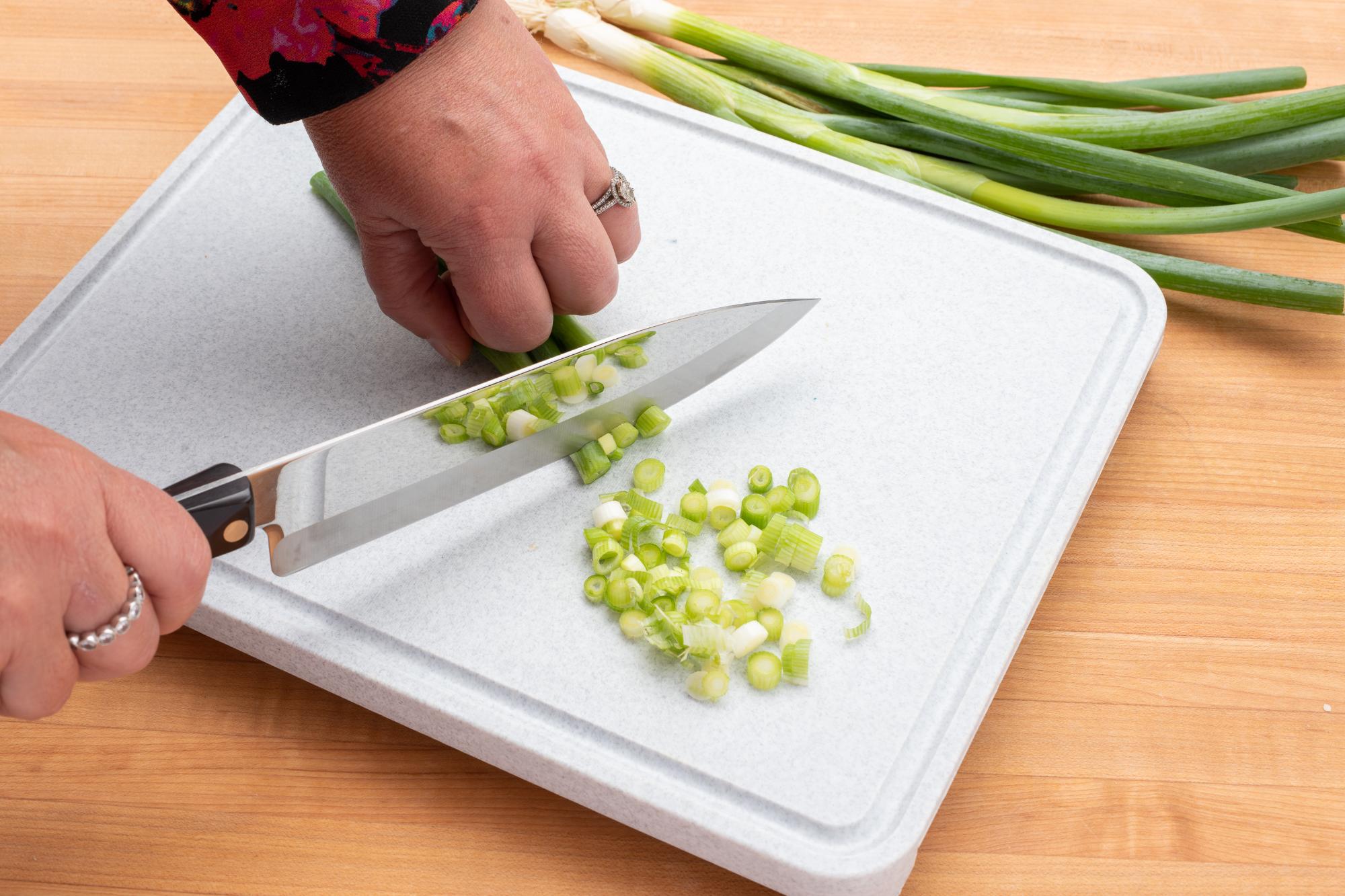 Slicing green onions with a Petite Chef knife.