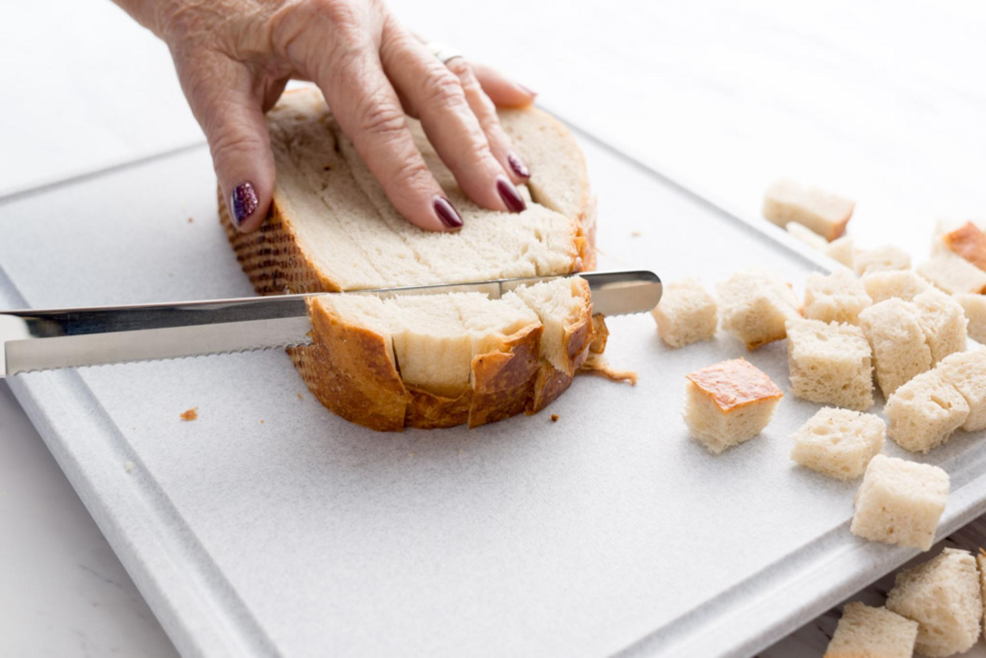 Slicing the bread into cubes.