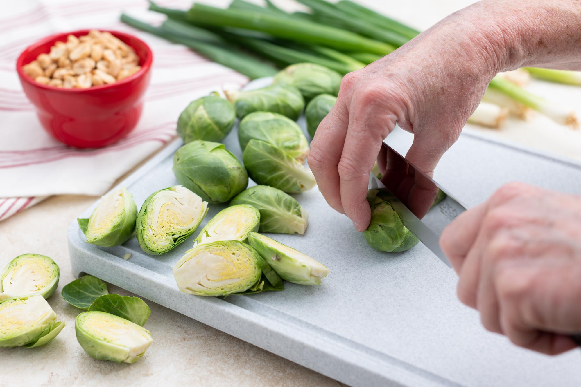 Cutting the brussels sprouts in half.