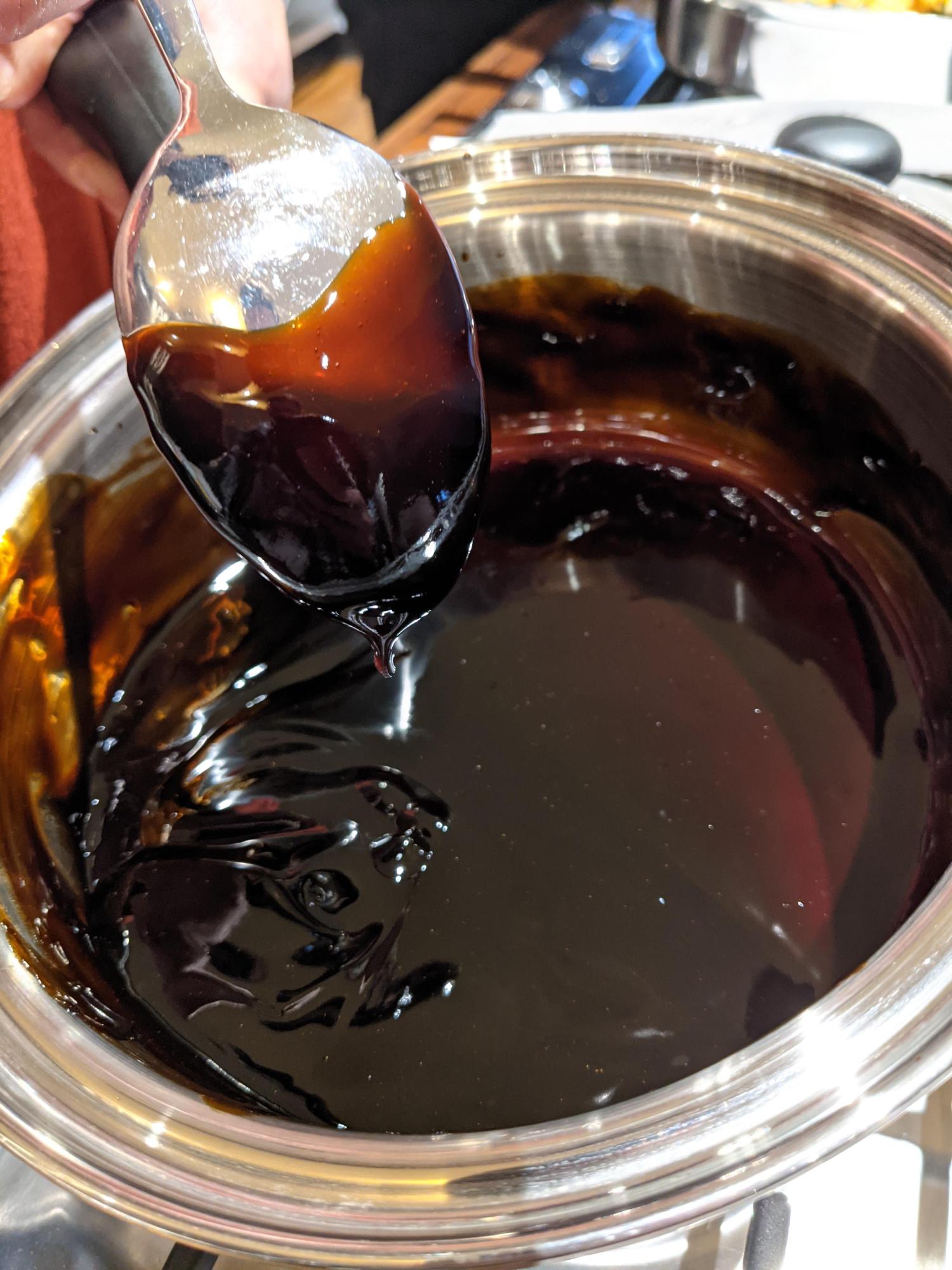 Balsamic reduction coating a spoon.