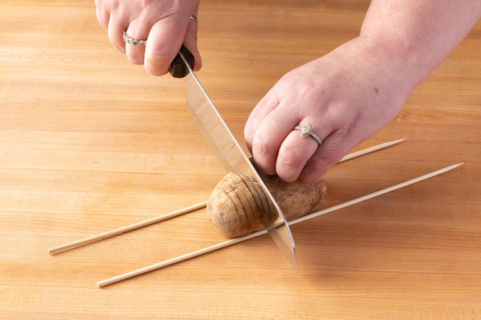 Slicing the potato with a Santoku.