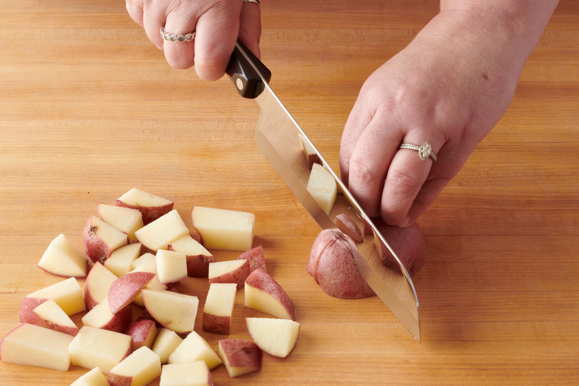 Cutting the red potatoes with a Santoku.