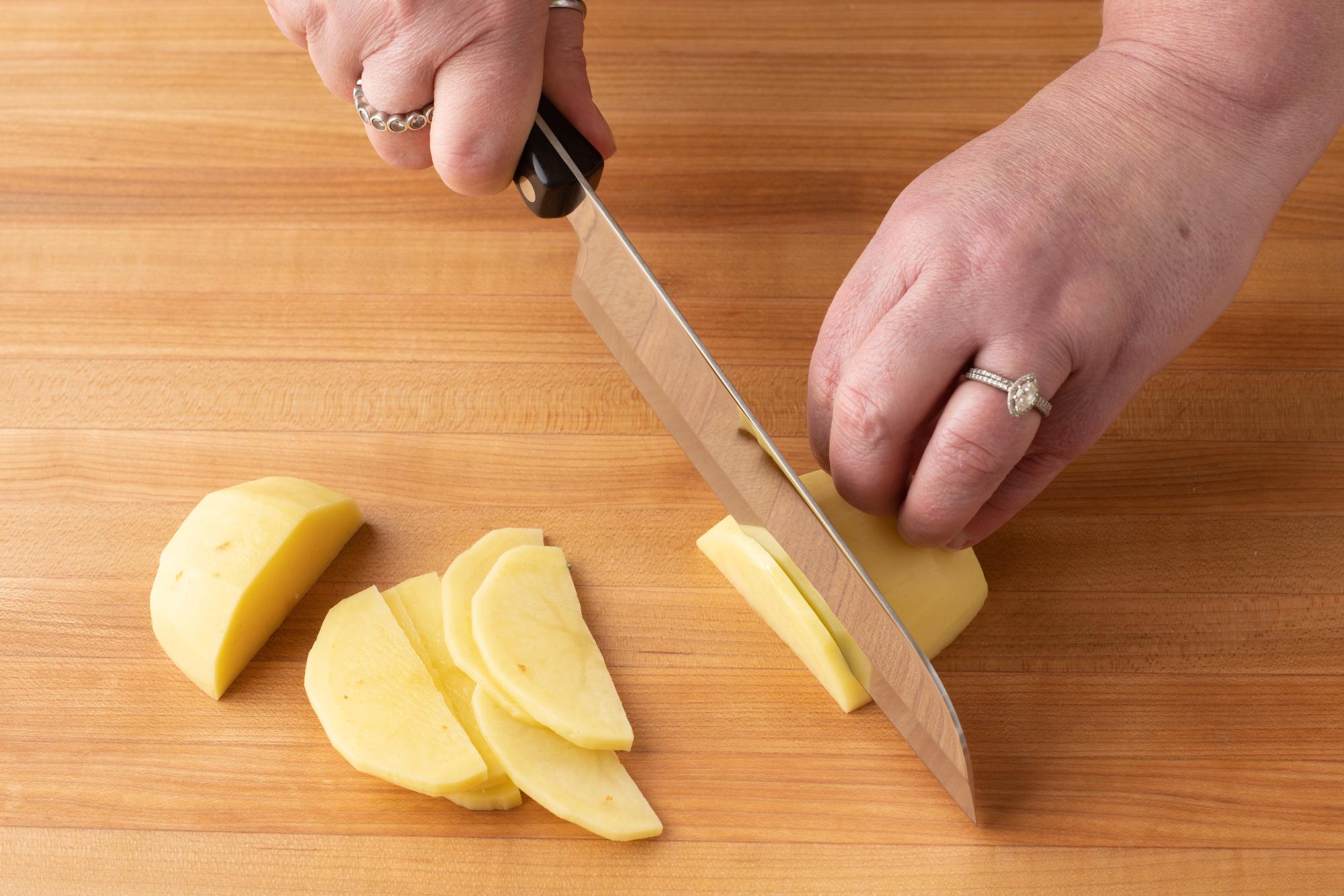 Slice the potatoes with a Santoku.