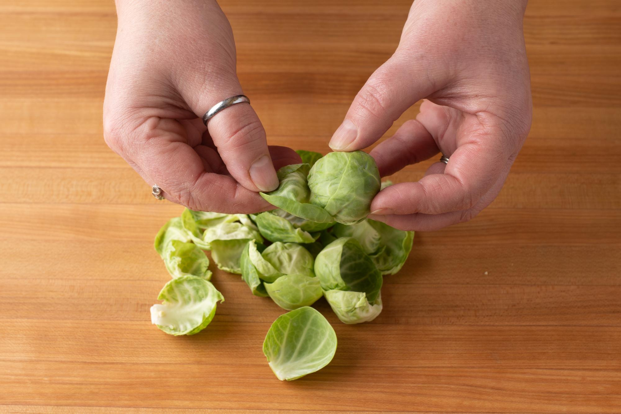 Peeling off the brussels sprouts leaves.