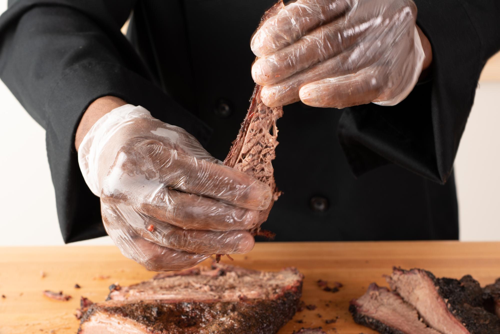 Pulling on a slice of brisket.