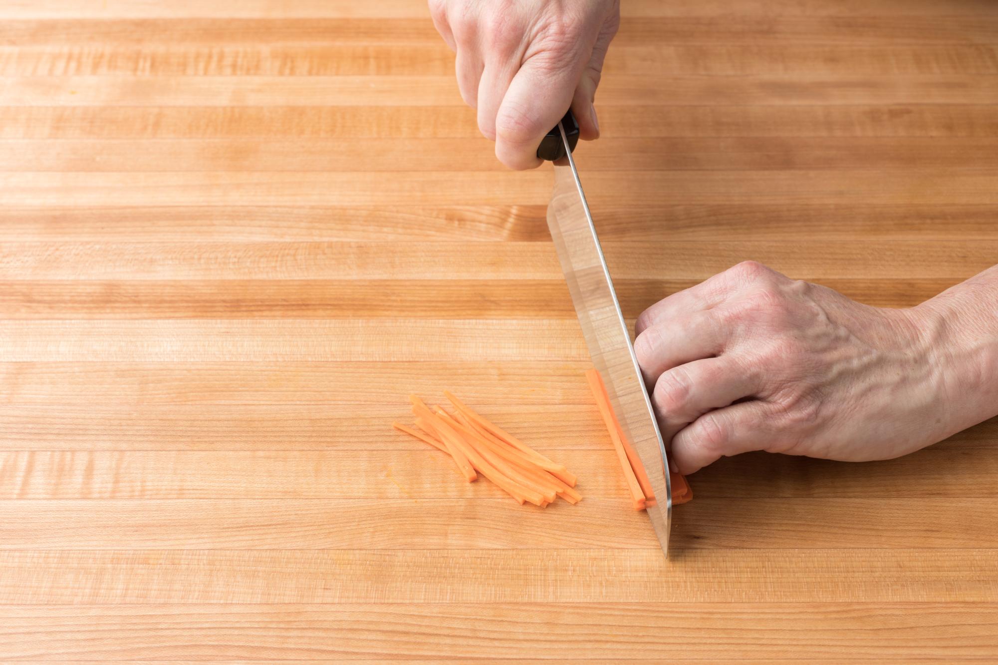 Cutting carrots into matchsticks with a Santoku.