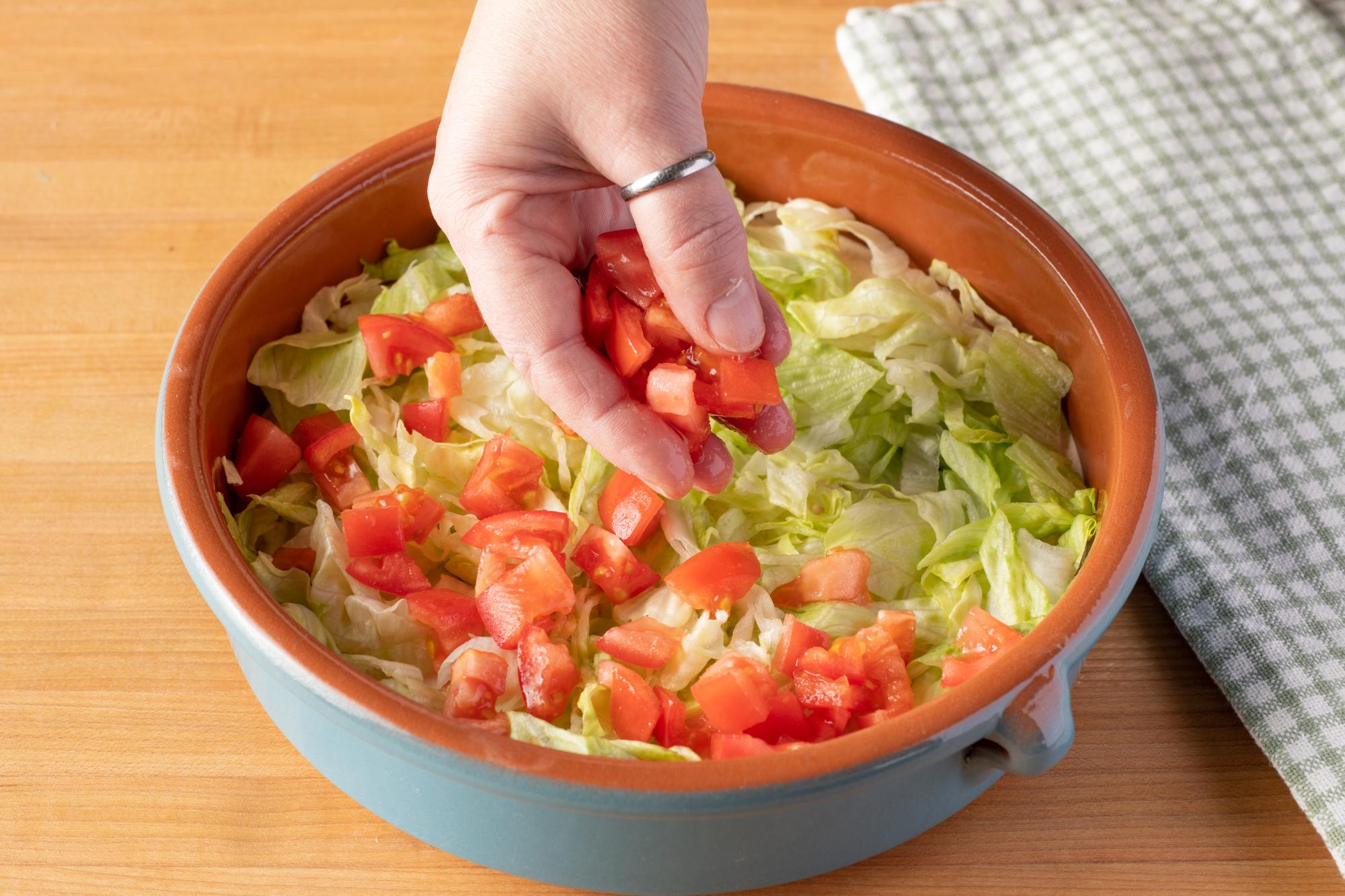 Layering tomatoes on top.