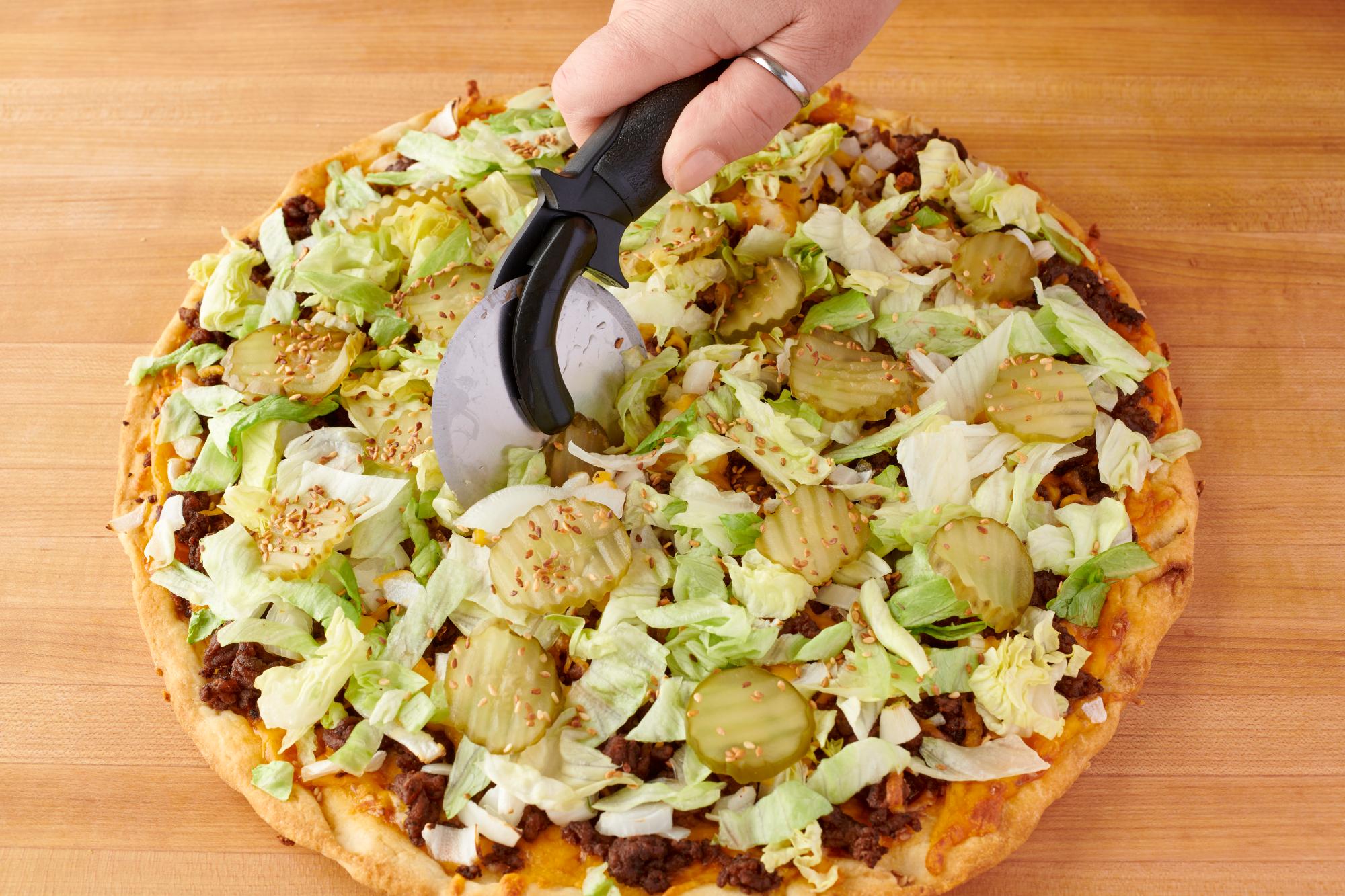 Using the Pizza Cutter to cut the pizza.