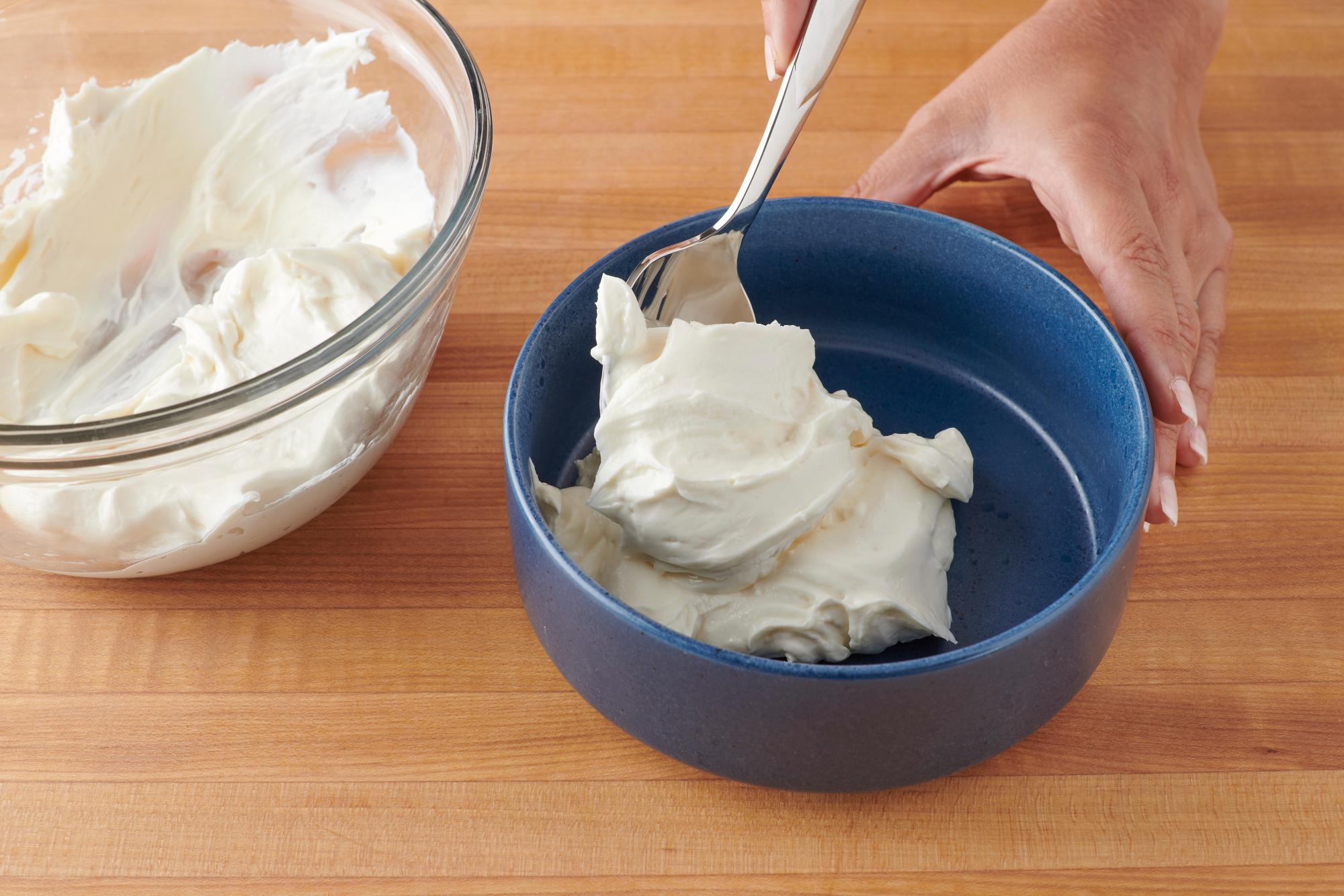 Spooning the cream cheese mixture into a dish.