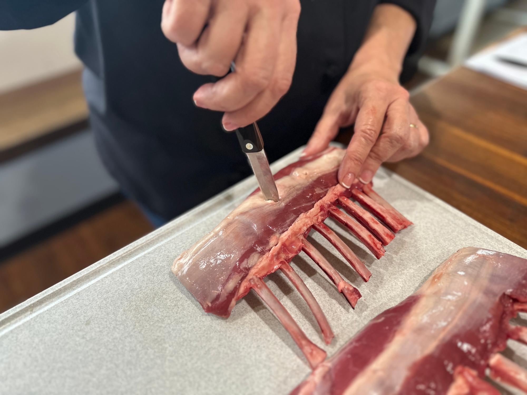 Making slits in the rack of lamb with a Paring Knife.
