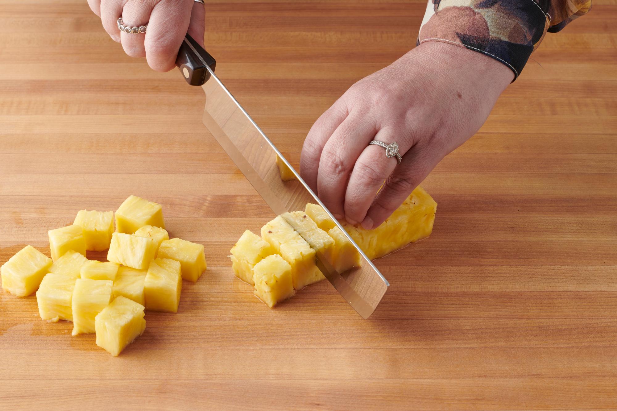 Cutting the fresh pineapple with a Vegetable knife.