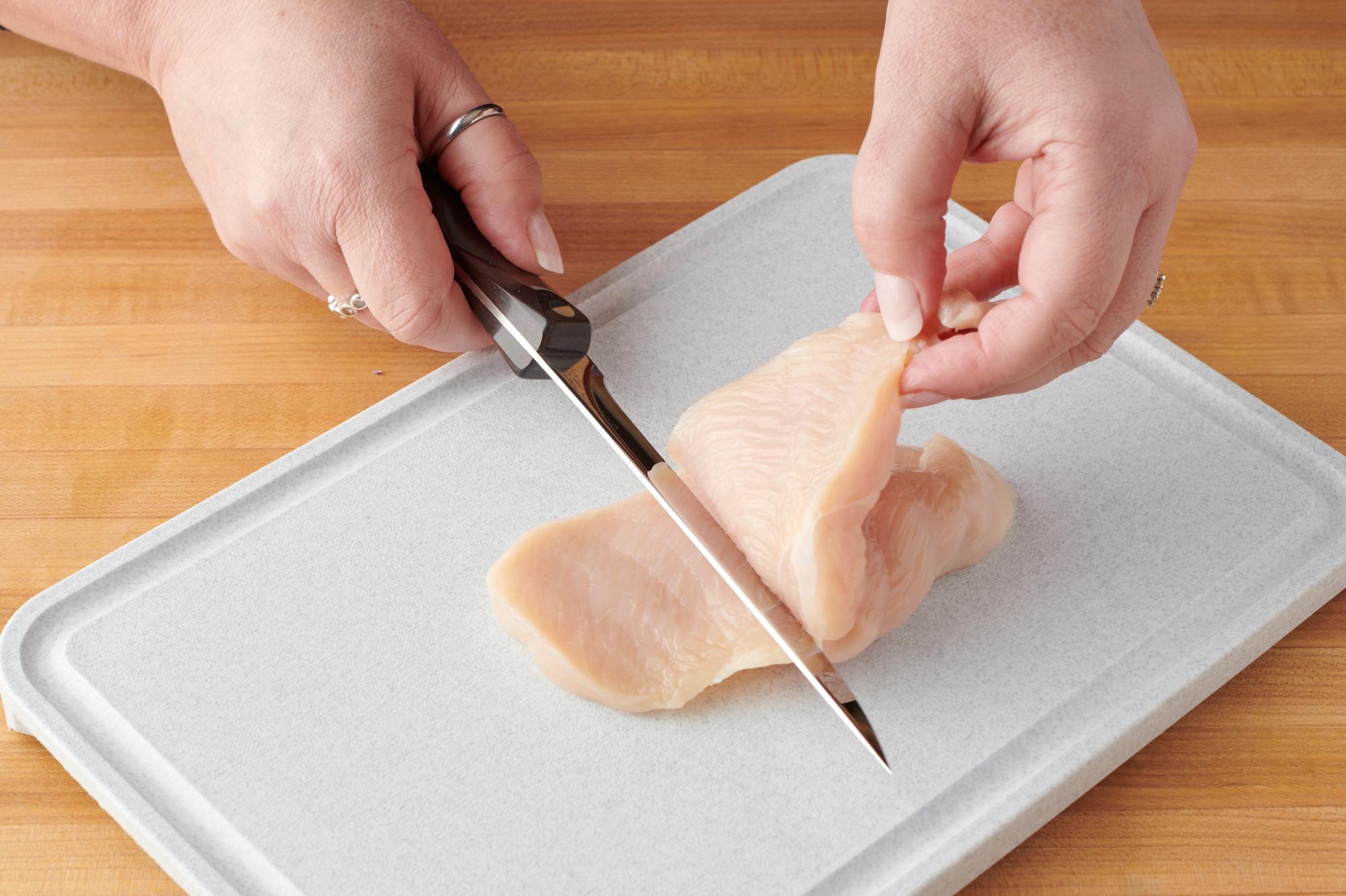 Using a Boning Knife to cut the breast in half.