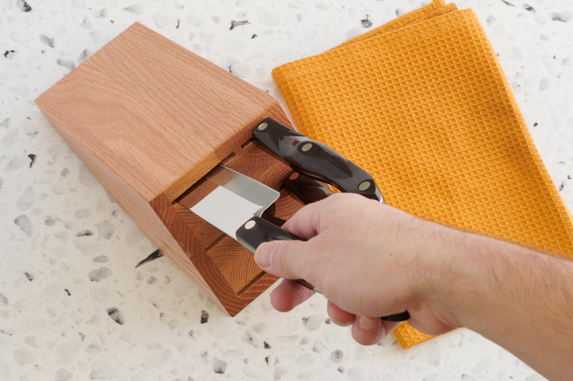 Placing knife in wood block.
