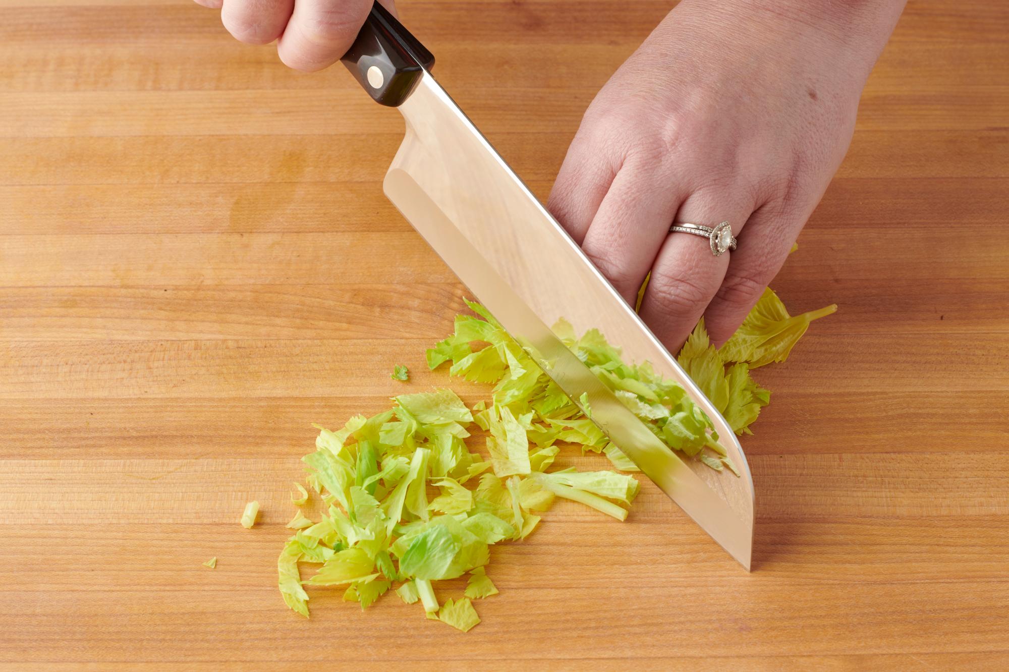 Chopping the celery leaves with a Santoku.