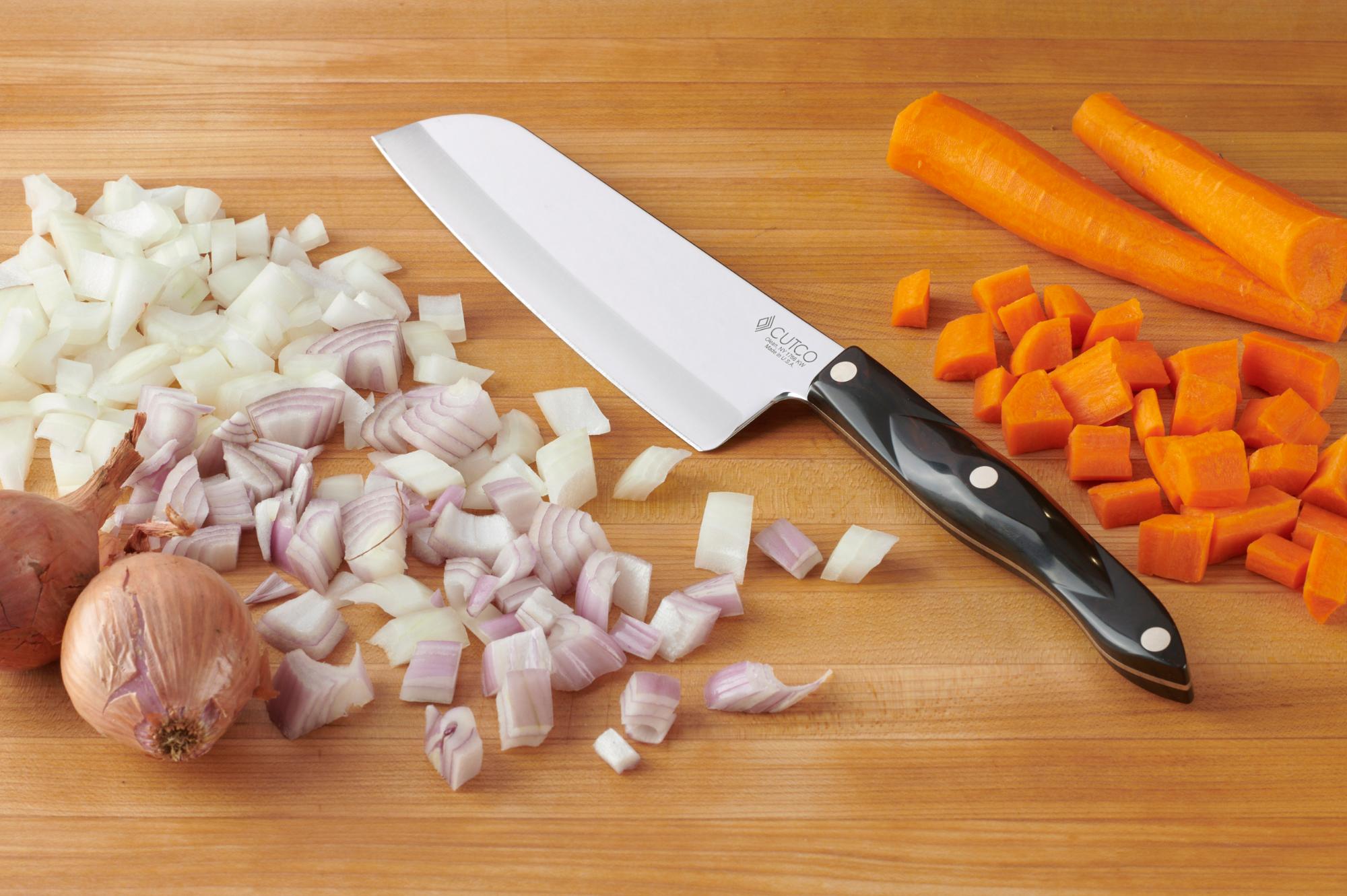 Chopped onion, carrots and shallot with a Santoku.