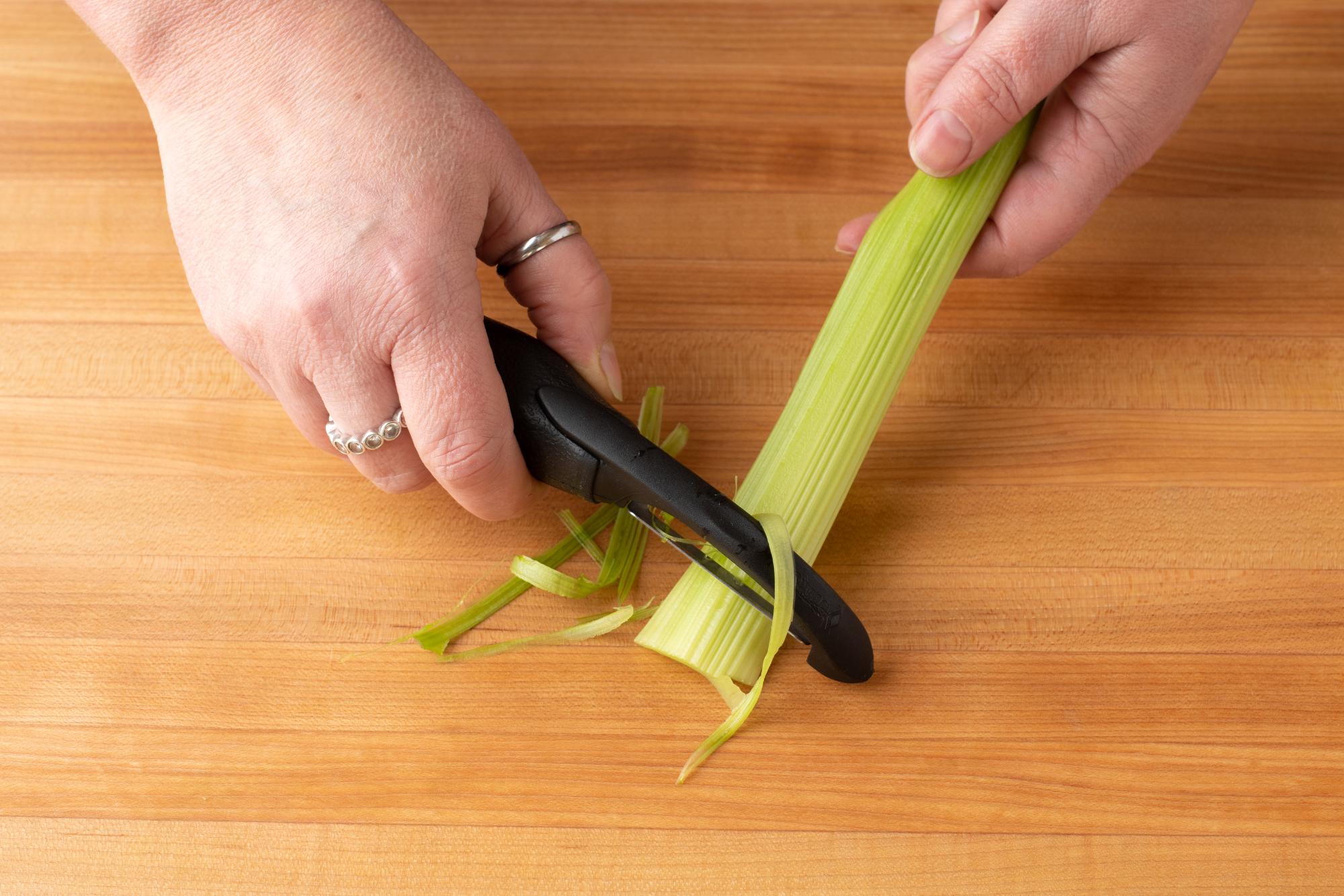 Using a Peeler to remove the fibrous strings on the celery.