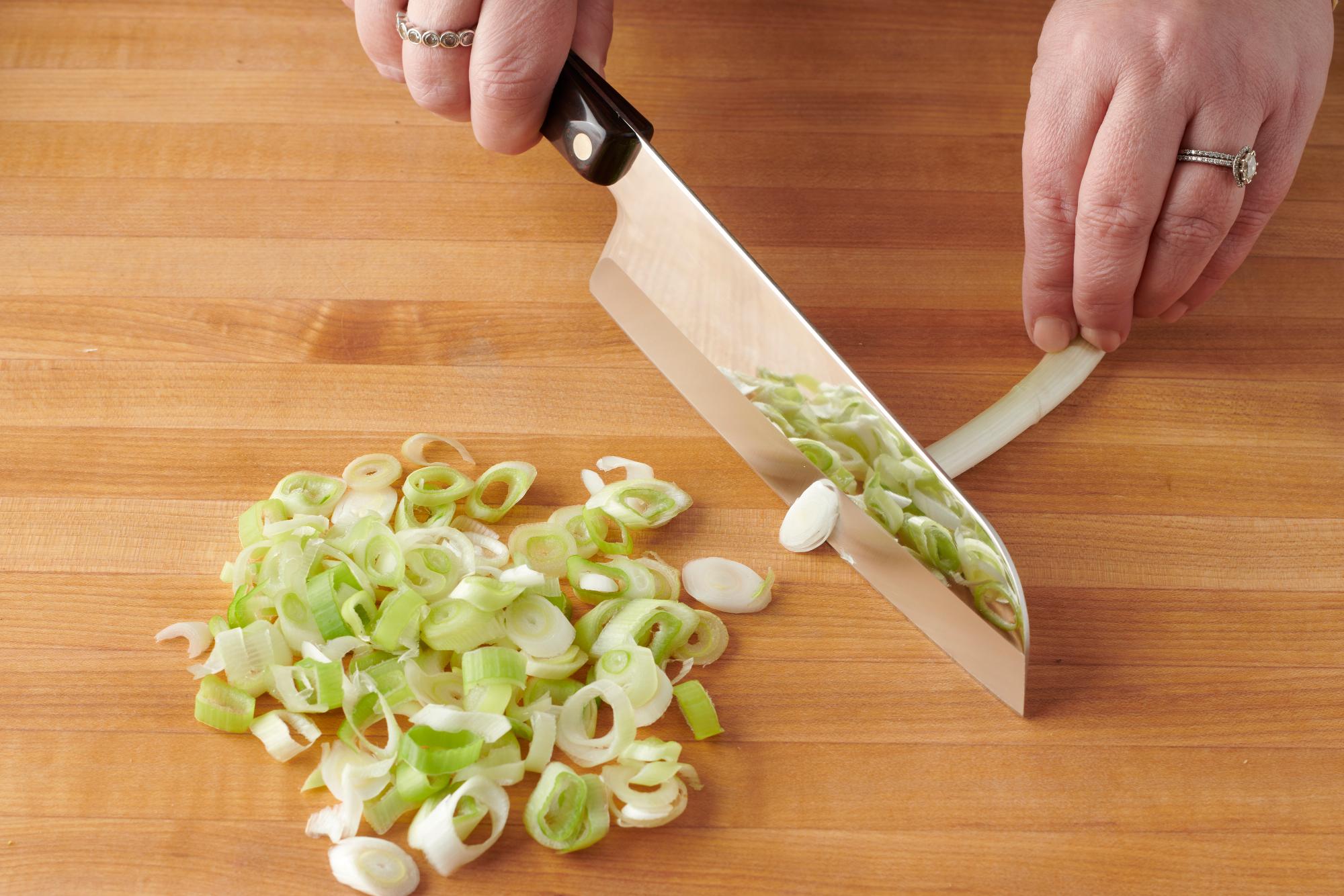 Slicing the green onion with a Santoku.