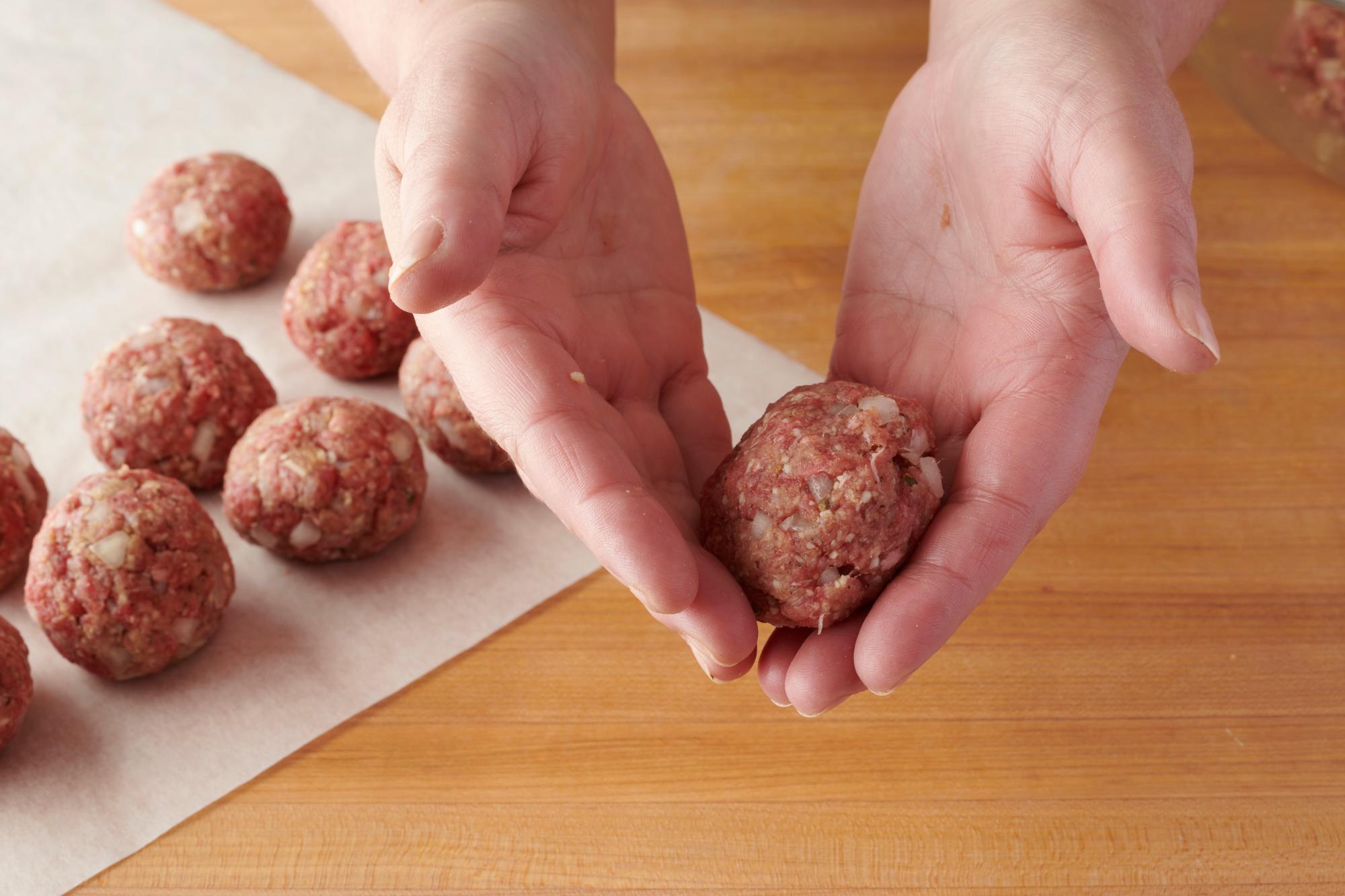 Rolling the meatballs by hand.