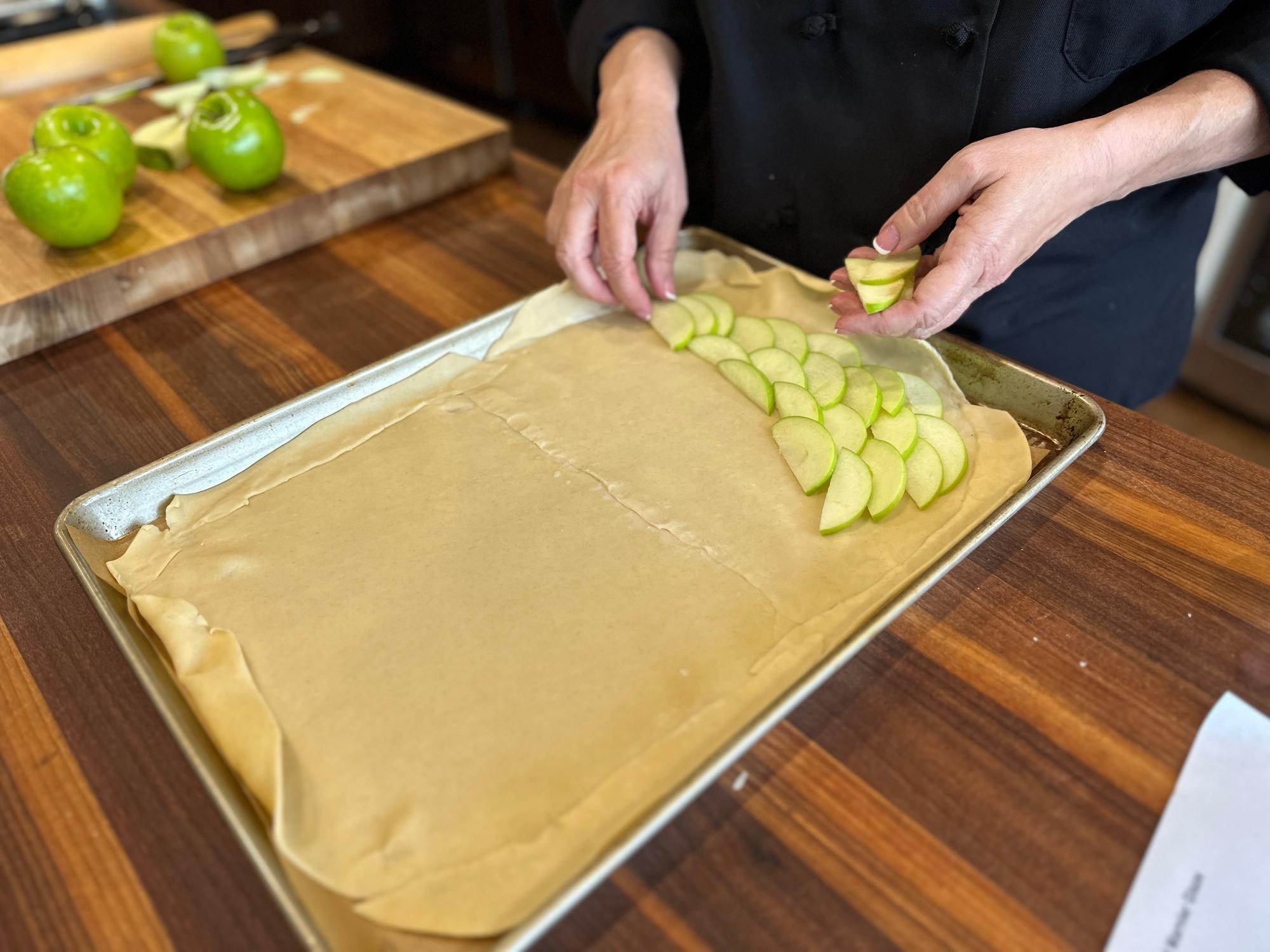 Layering apples on the dough.