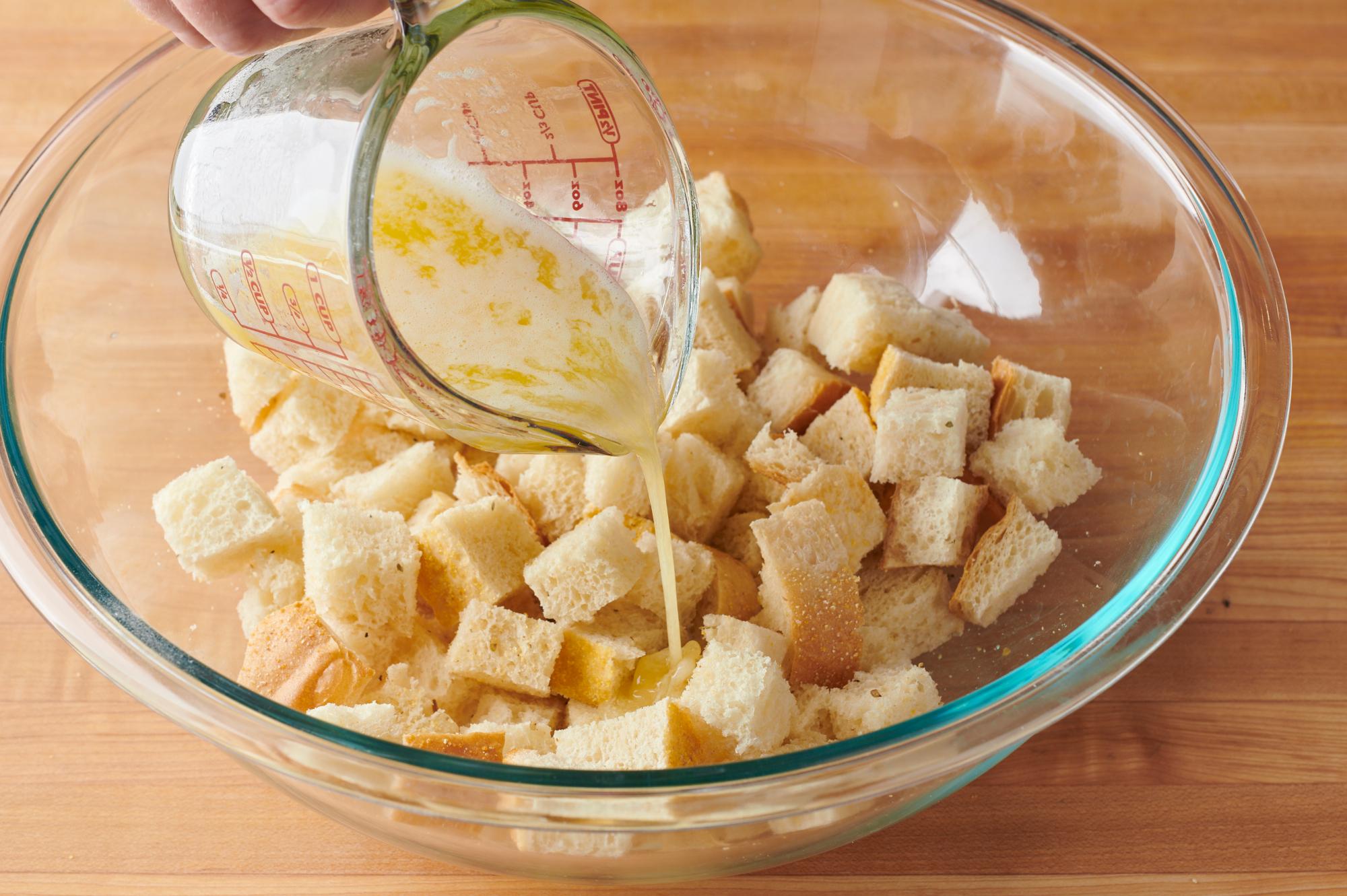 Drizzling butter over the bread.