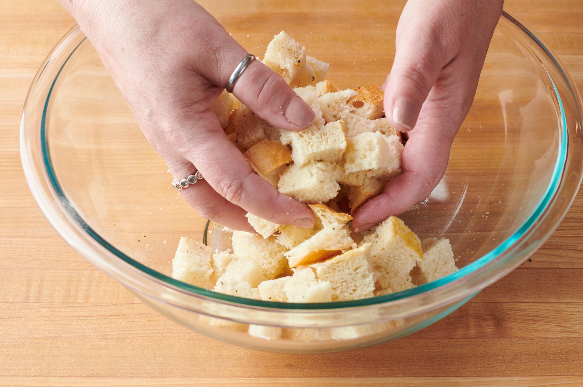 Tossing the bread with the seasonings.