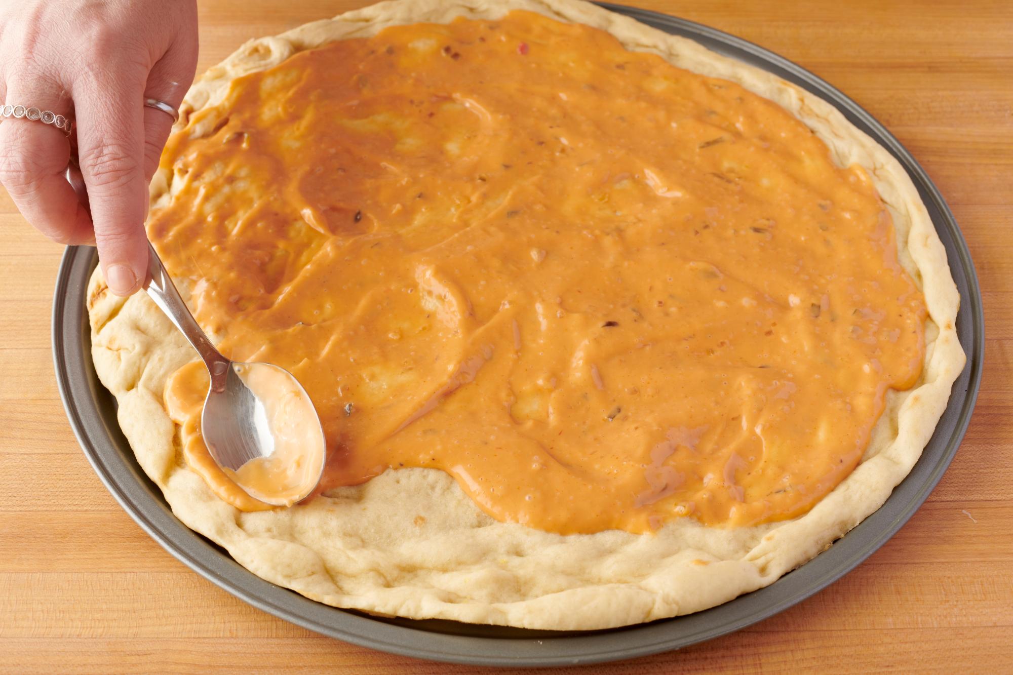 Spread the salad dressing on the crust.