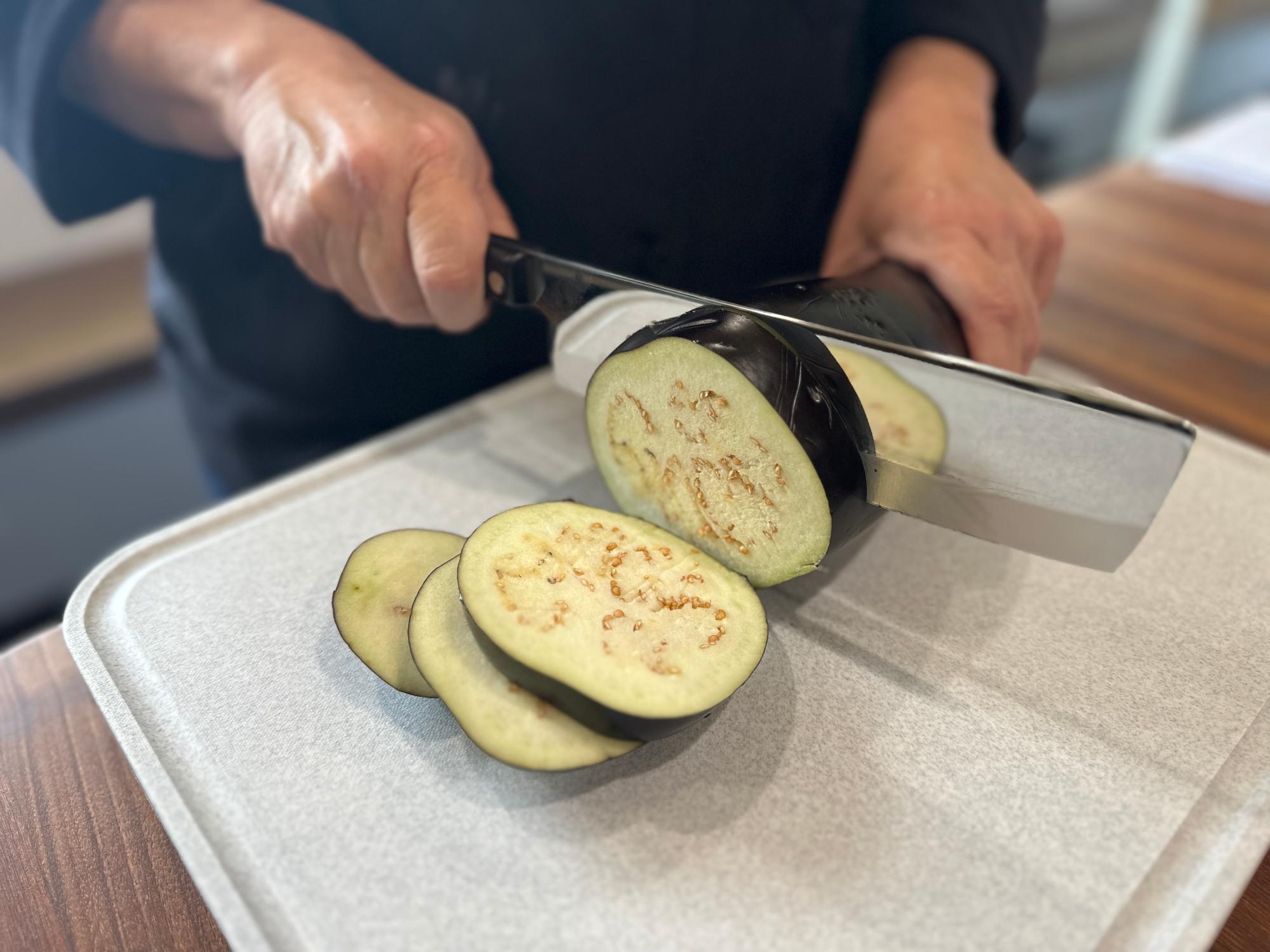 Slicing the eggplant with a Vegetable Knife.