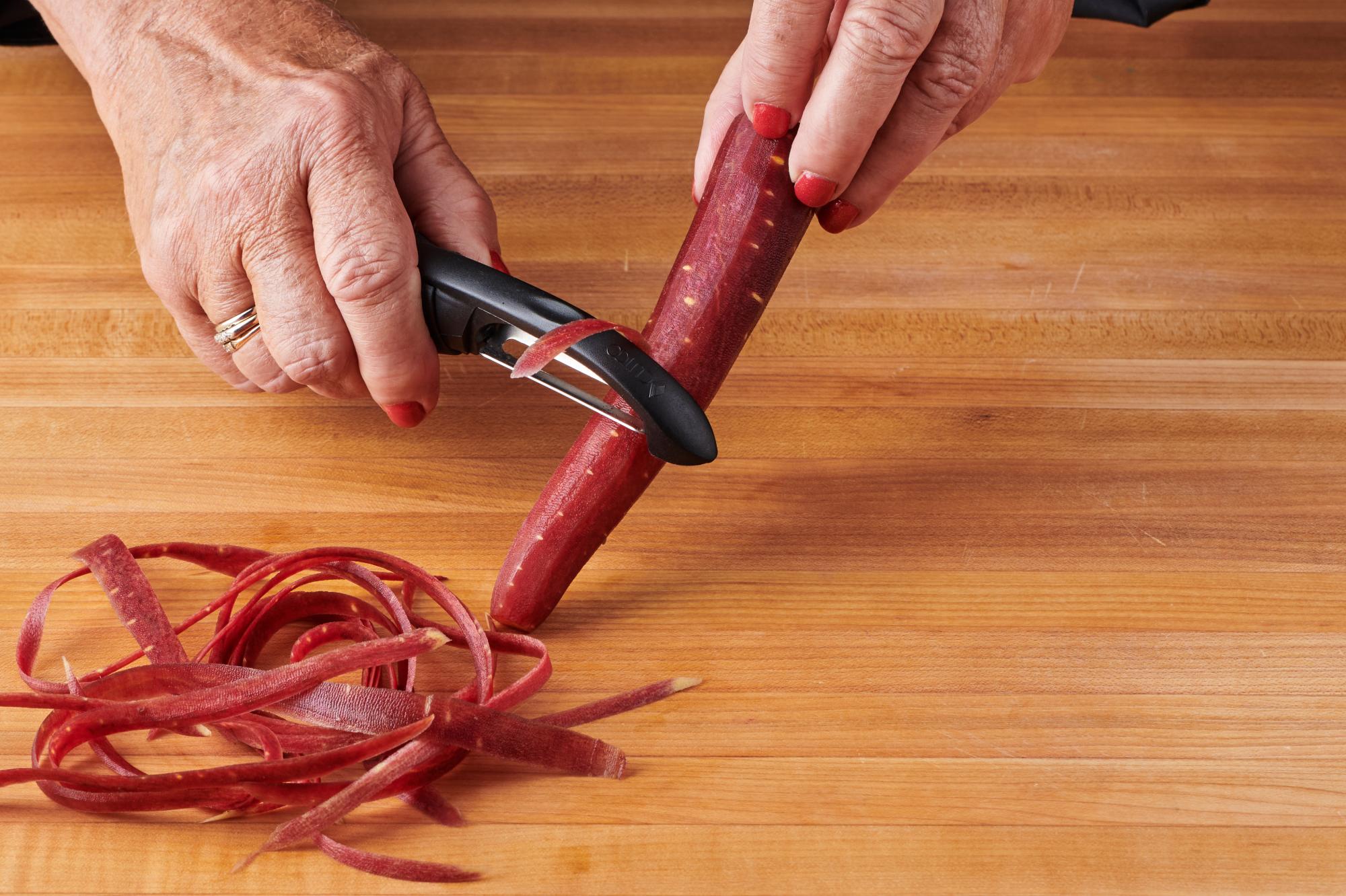  running a Vegetable Peeler along the carrots