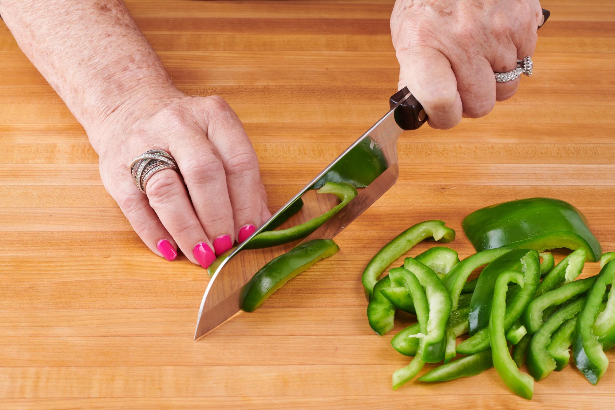 Slicing the bell pepper with a Santoku.