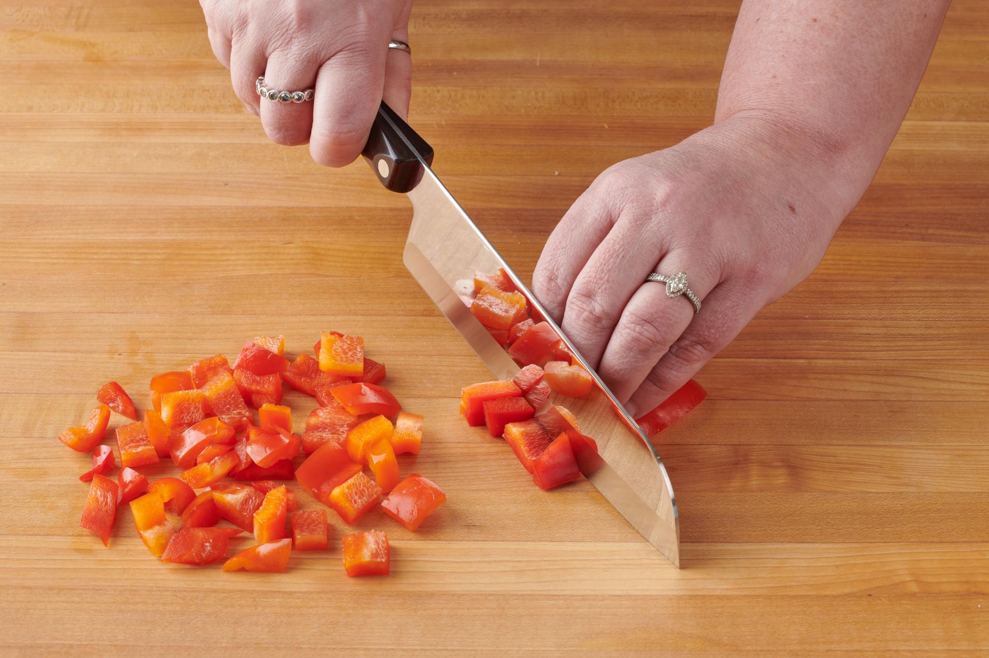 Chopping red pepper with a Santoku.